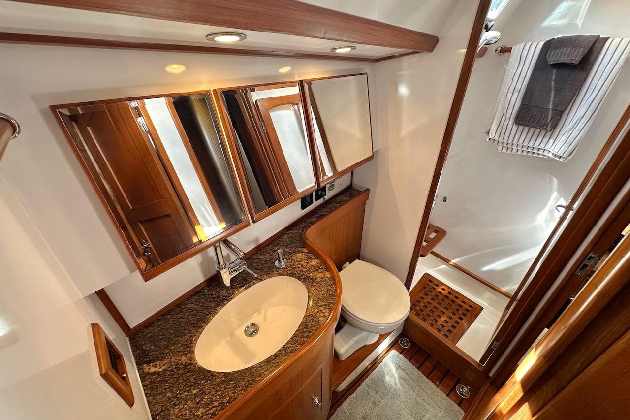 Luxurious bathroom in 2012 Hylas 56 yacht with granite countertop and wooden accents.