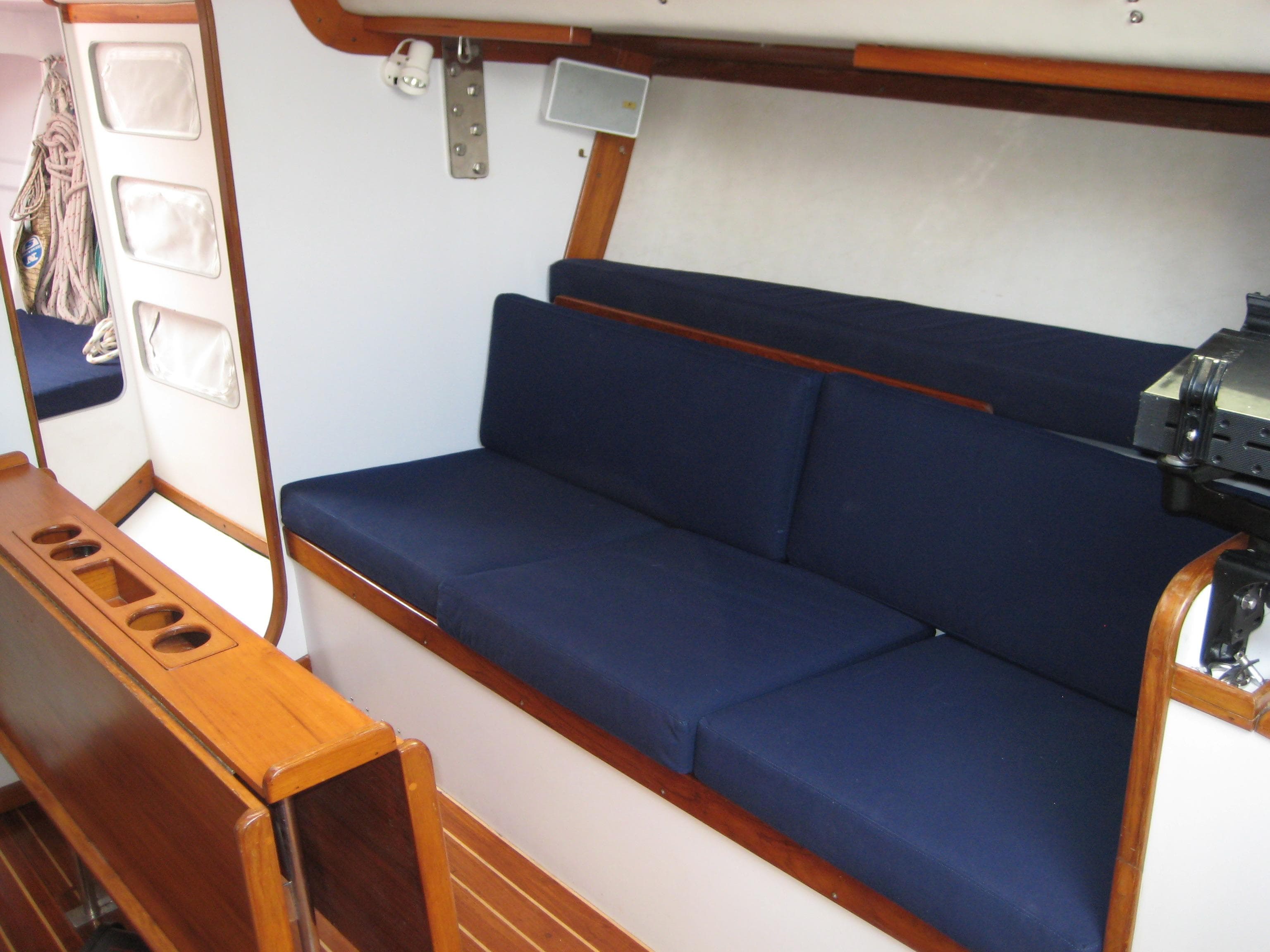 Interior of 1991 J Boats J/39 sailboat with blue cushions and wooden accents.