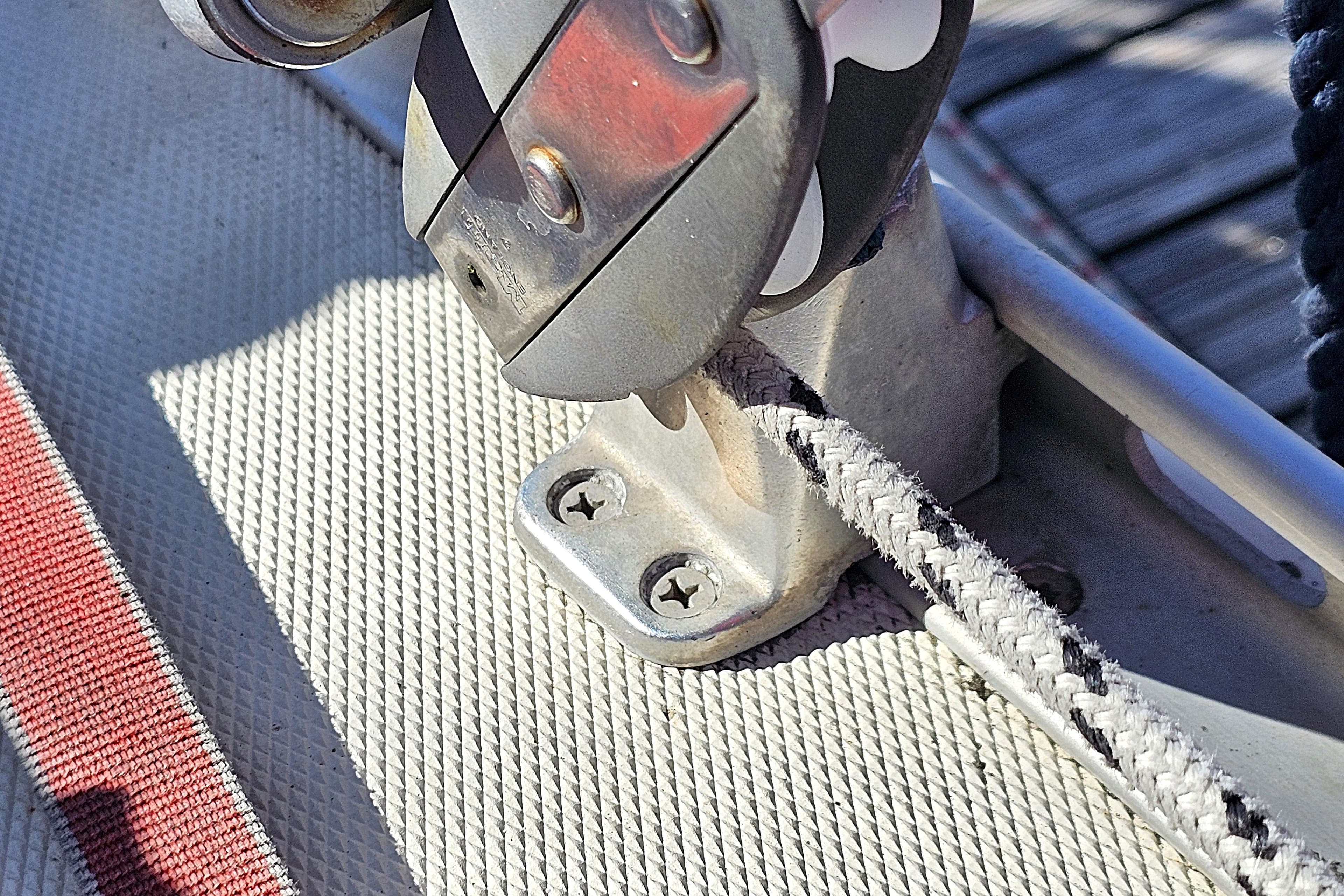 Close-up of a 2003 Hanse 341 sailboat deck fitting with rope and pulley system.