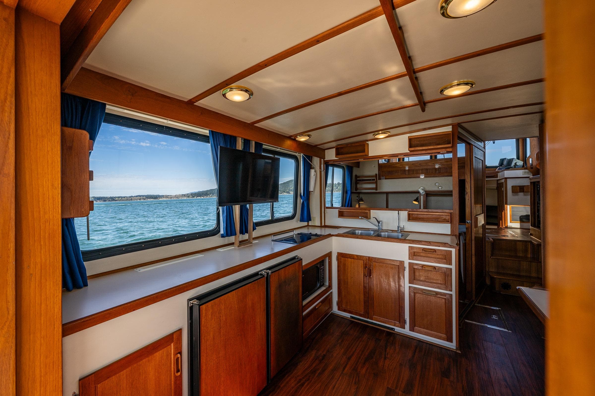 Interior of 1999 Pacific Trawler 40 with wooden cabinetry and ocean view.