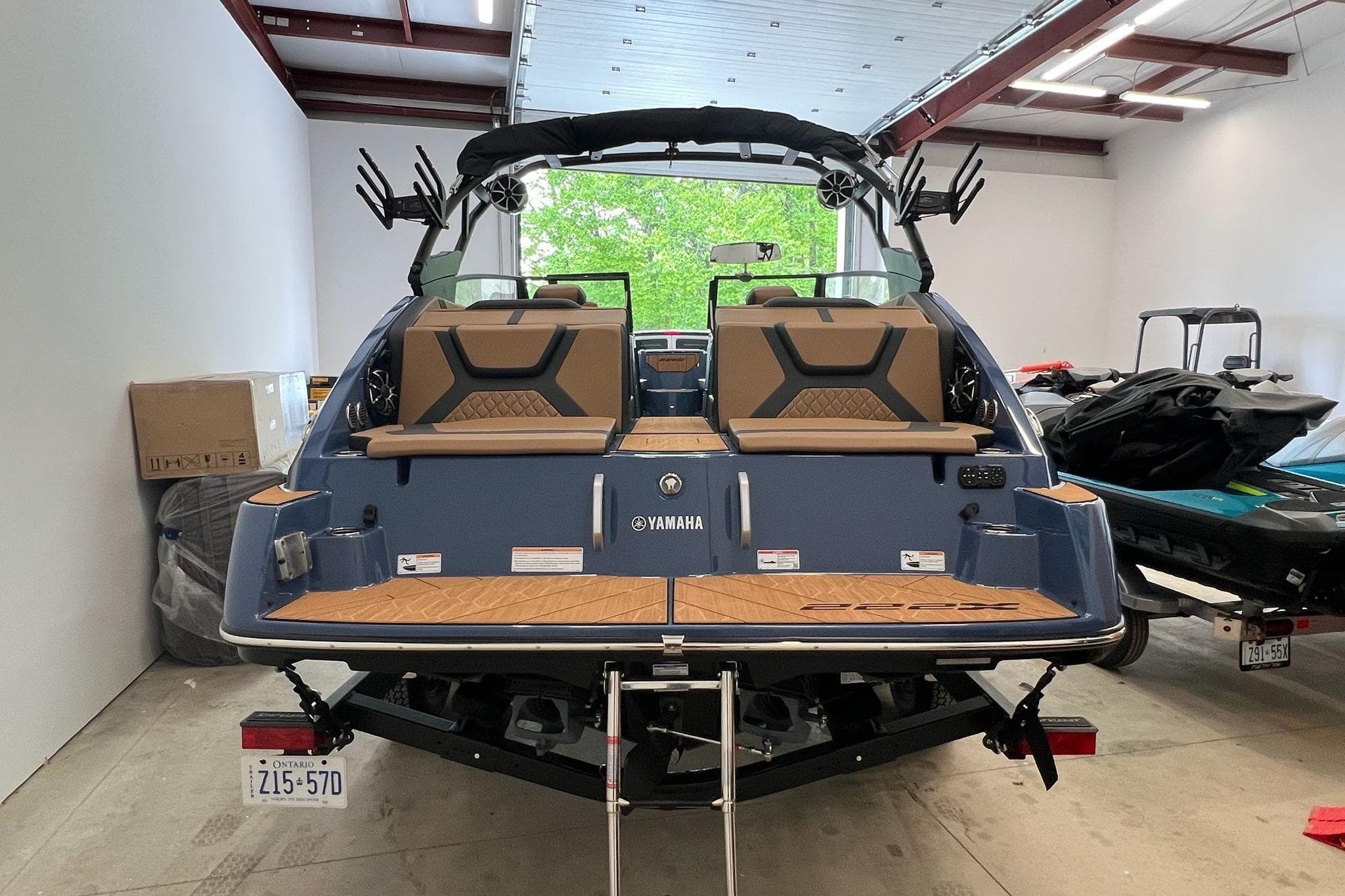2024 Yamaha 222X boat in a garage, showcasing rear seating and swim platform.