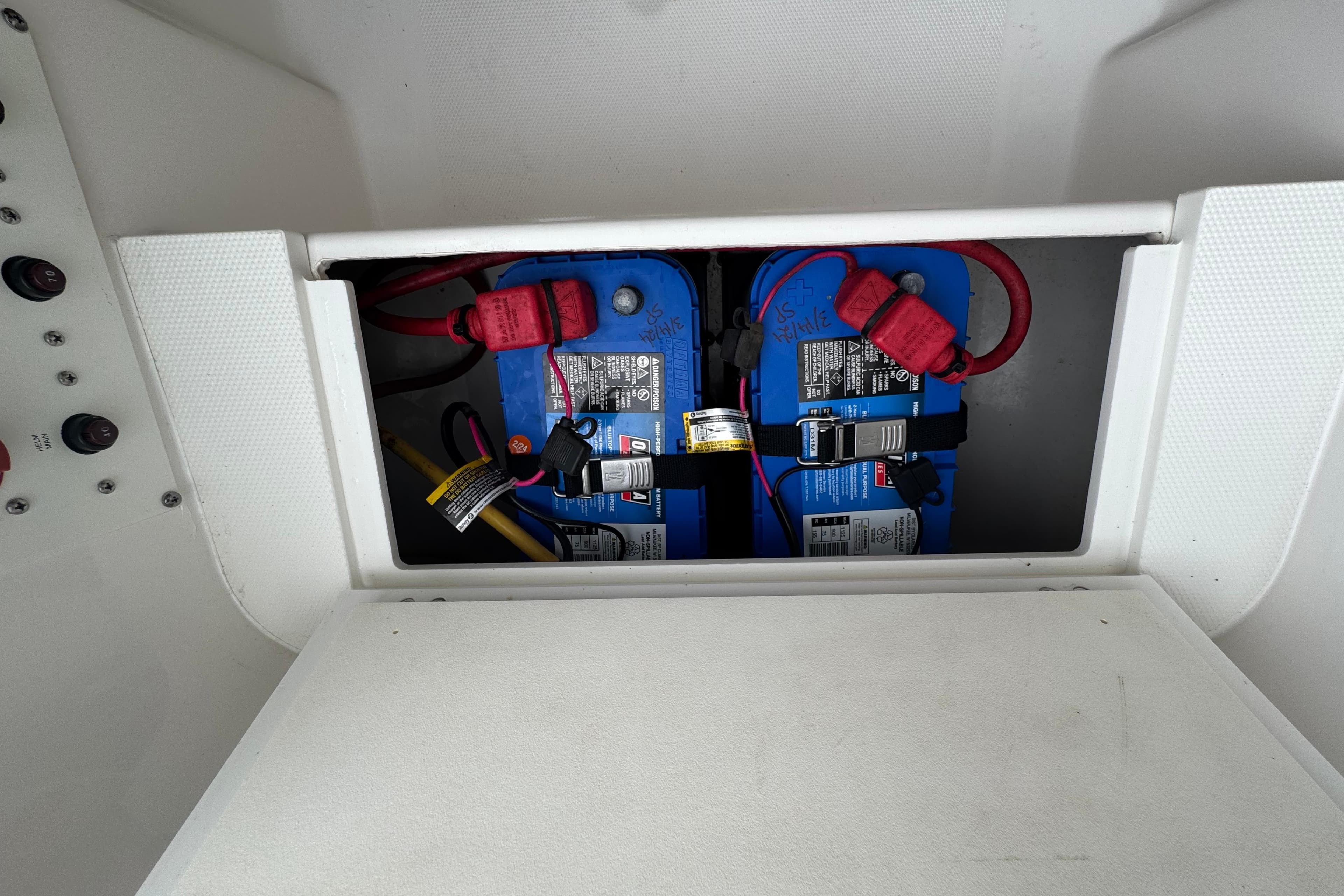 Battery compartment of a 2019 Edgewater 230CC boat, featuring dual blue batteries.