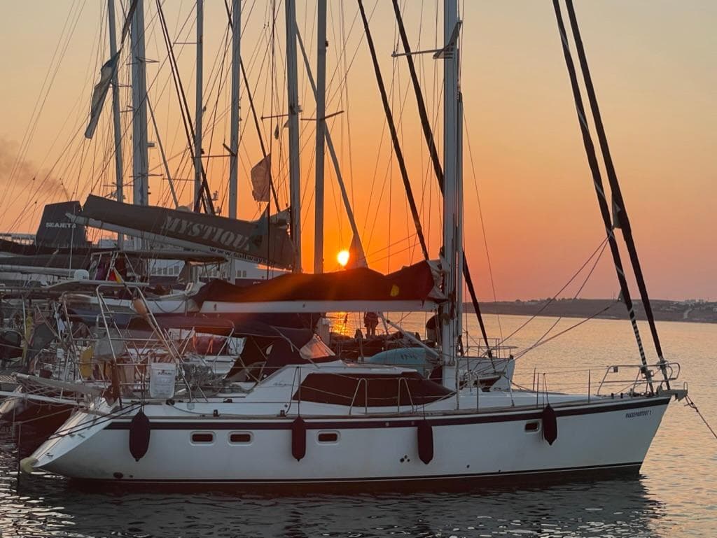 Sailboat Wauquiez 43 Pilot Saloon 2000 at sunset in marina.