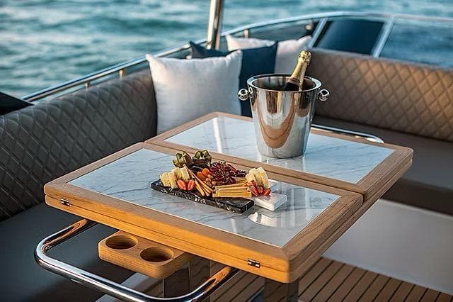 Luxurious Schaefer 600 yacht interior with champagne and charcuterie on a stylish table.