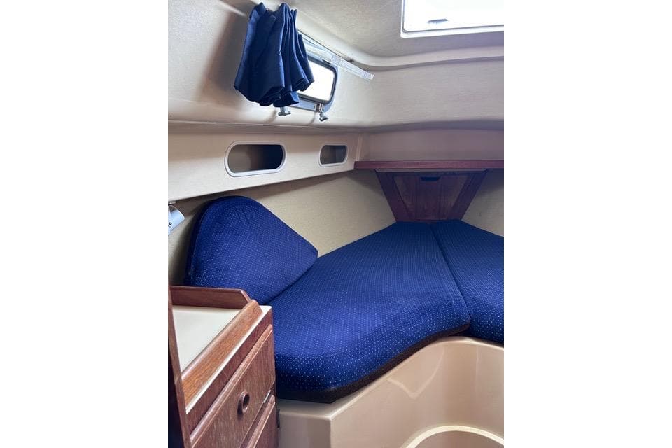 Interior cabin of a 1984 Pearson 34 sailboat with blue cushions.