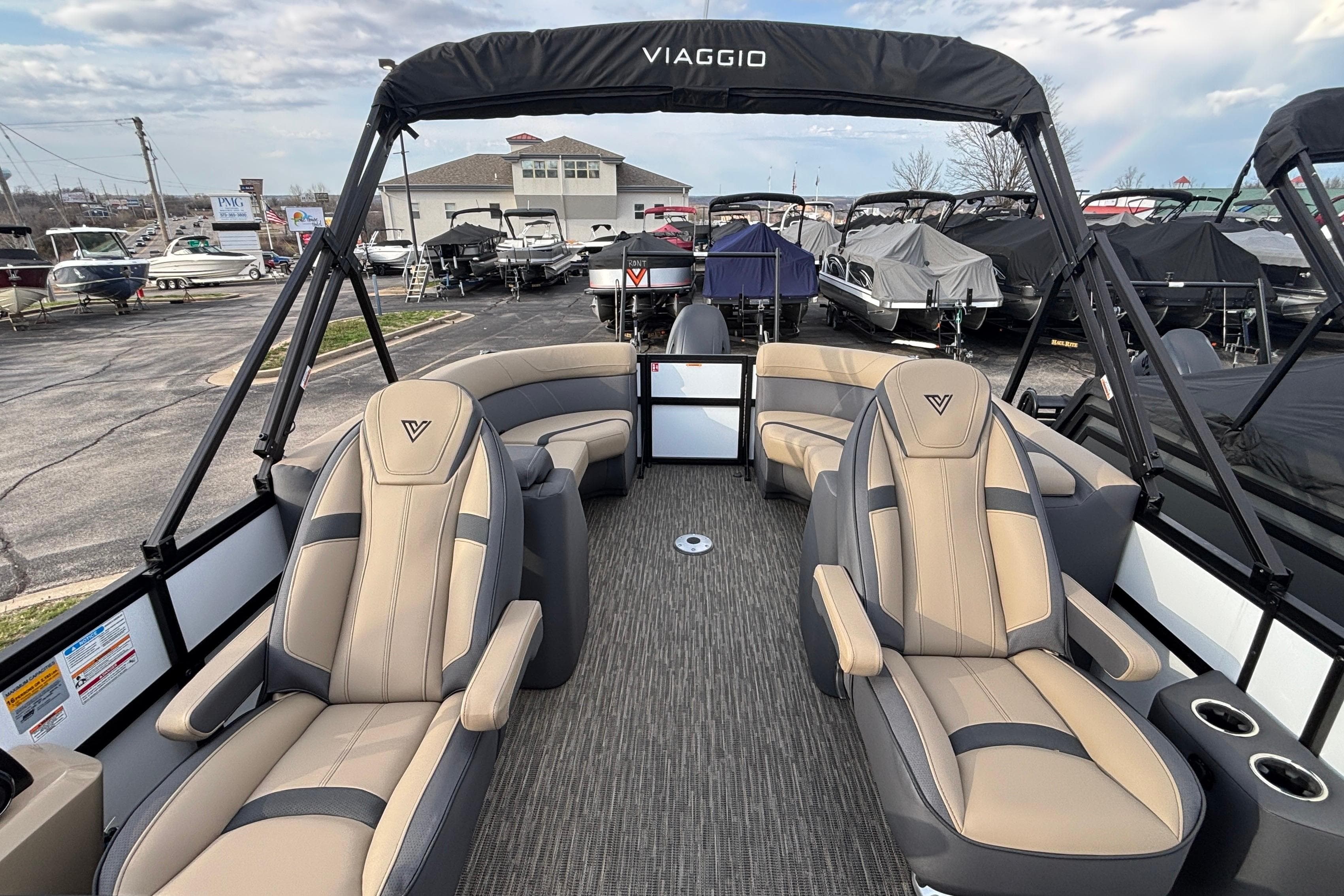 2026 Viaggio Lago X24U boat interior with luxurious seating and canopy in a marina setting.