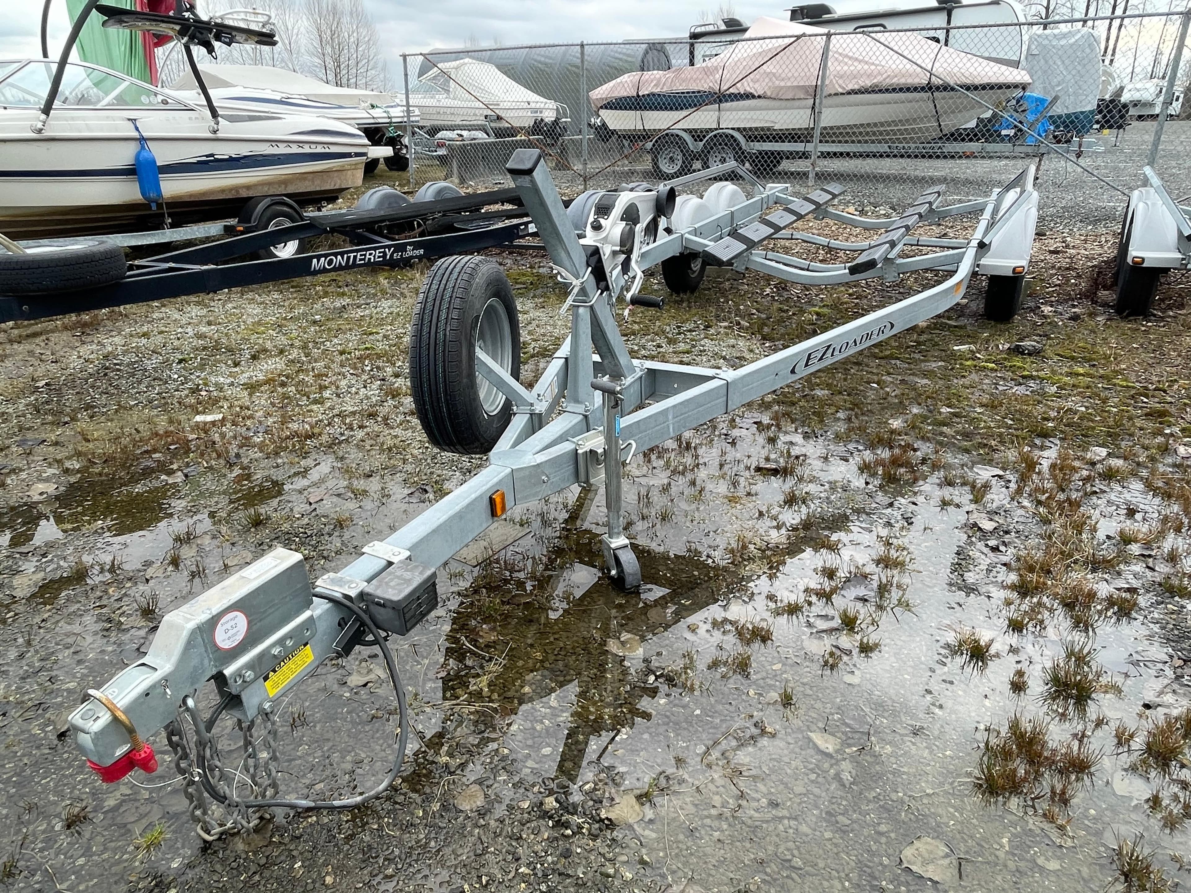 Trailer for Thunder Jet 210 Luxor Limited 2021, parked on wet gravel near other boats.