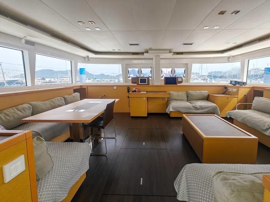 Spacious interior of 2012 Lagoon 560 yacht with modern furnishings and panoramic windows.