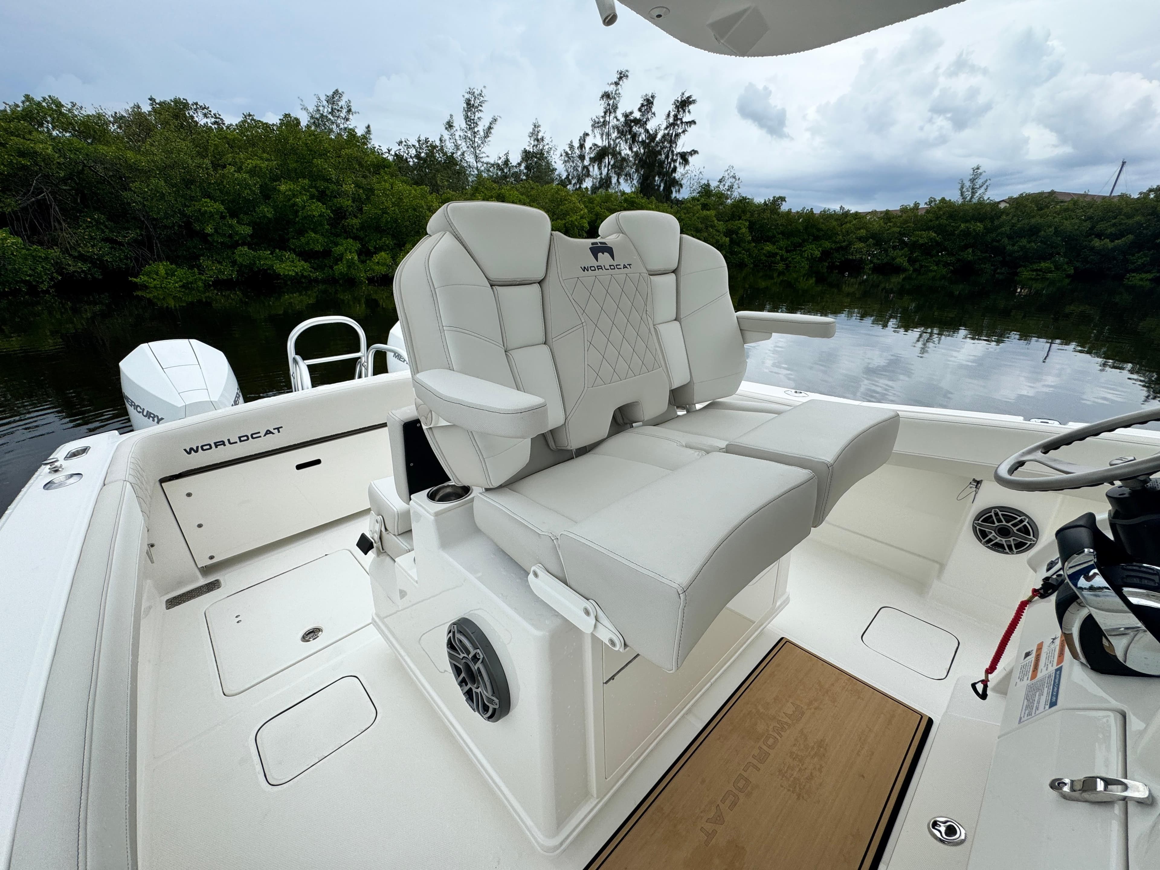 2025 World Cat 280 CC-X boat interior with plush seating and scenic water backdrop.
