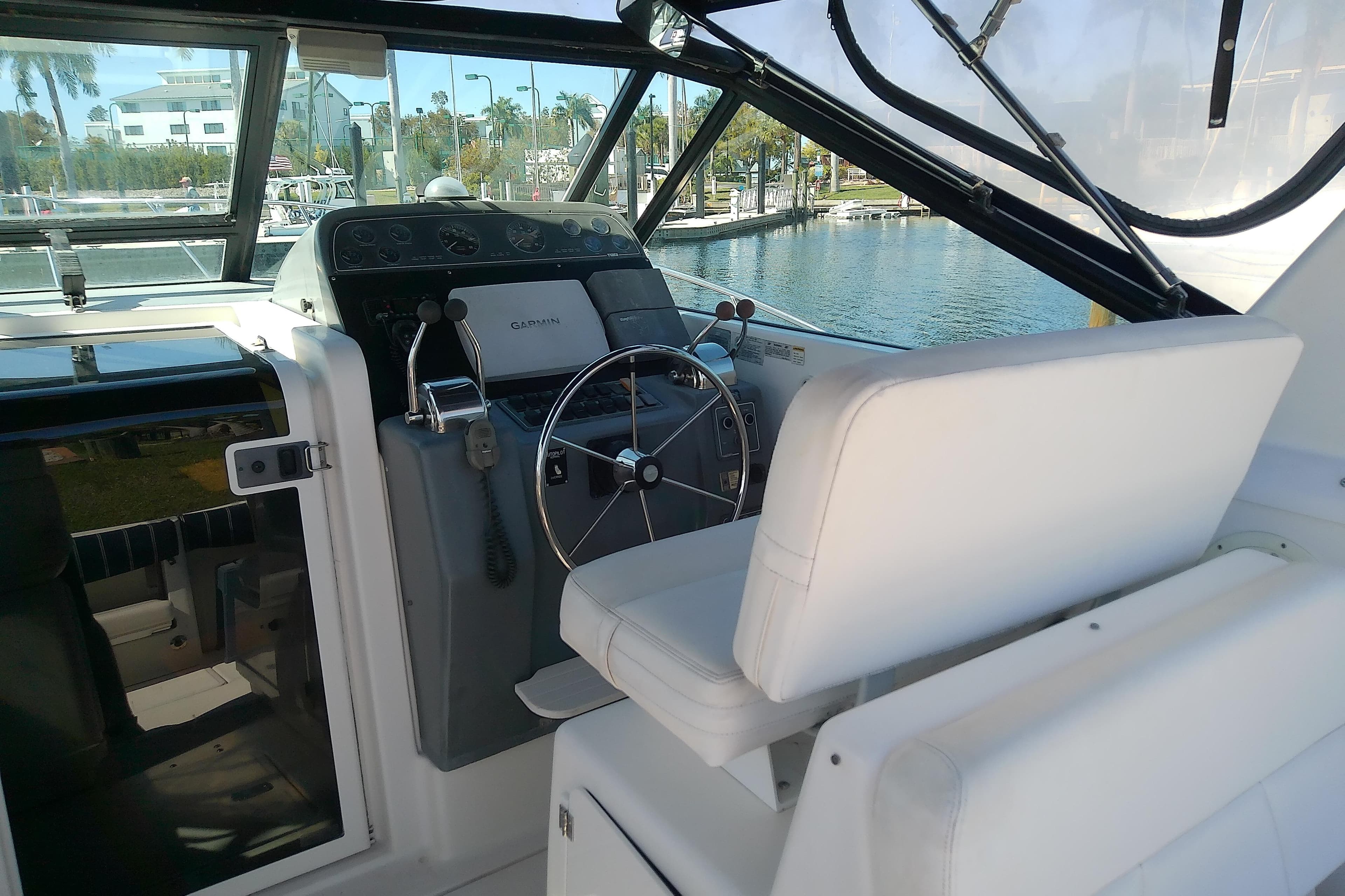 Cockpit of 2000 Tiara Yachts 3100 Open with steering wheel and Garmin navigation.