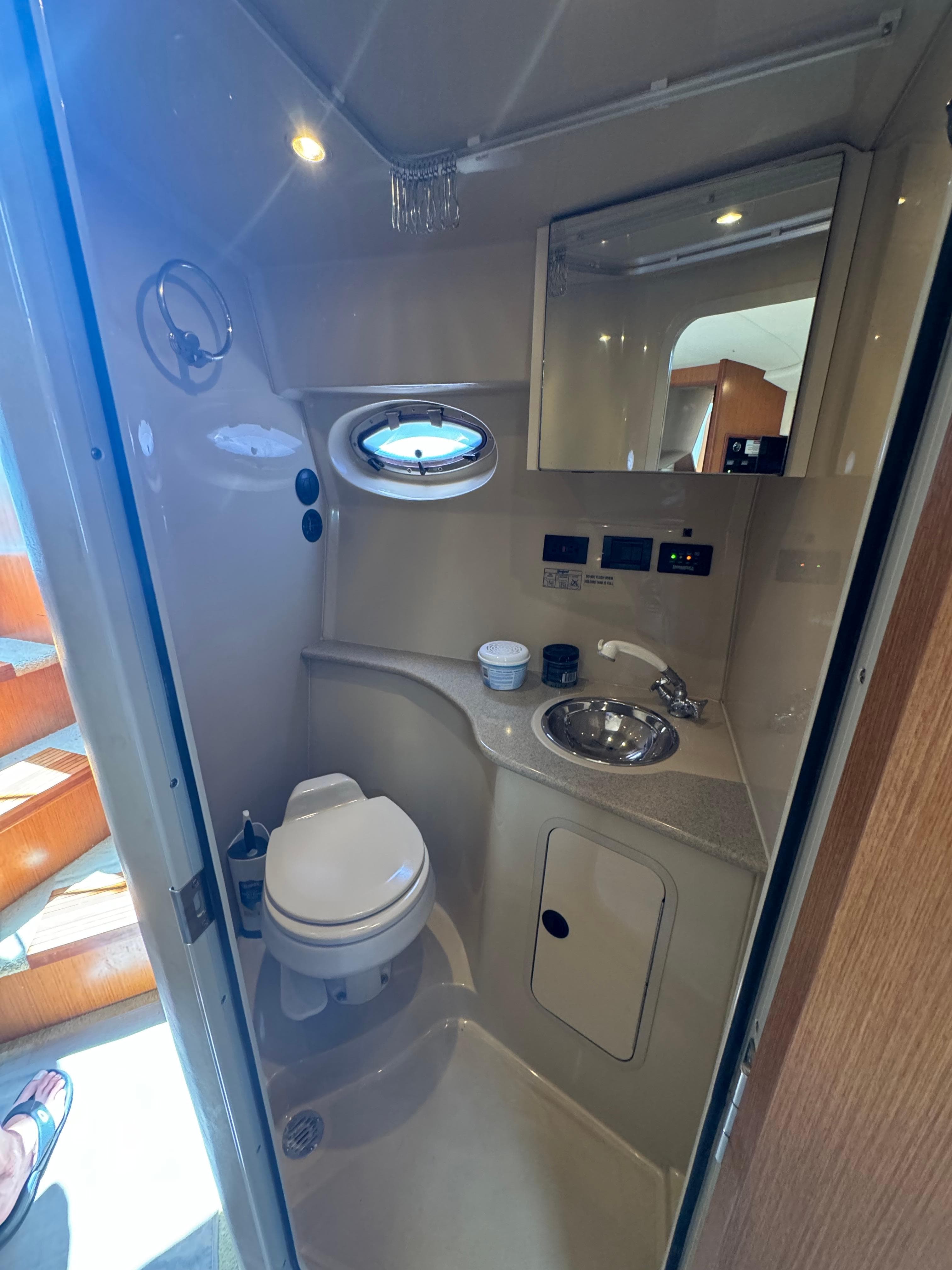 2004 Cruisers Yachts 320 Express bathroom with toilet, sink, and mirror.