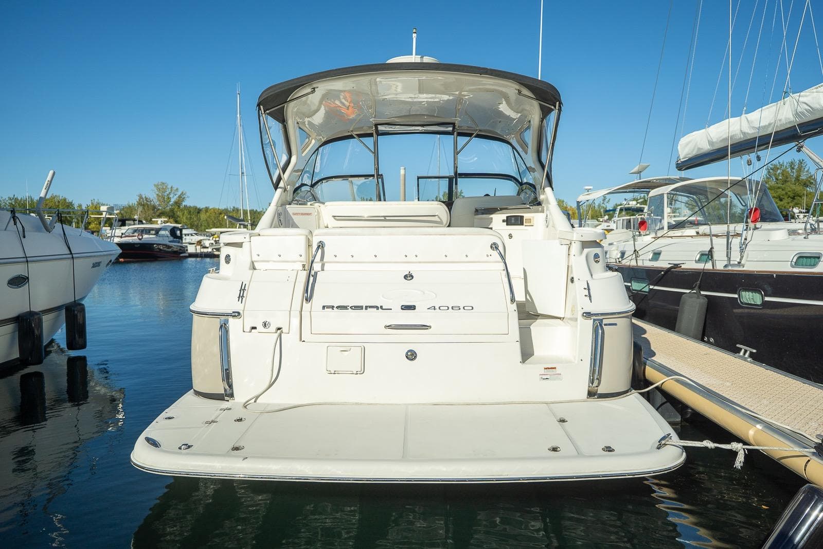 2009 Regal Commodore 4060 yacht docked at marina, clear blue sky background.