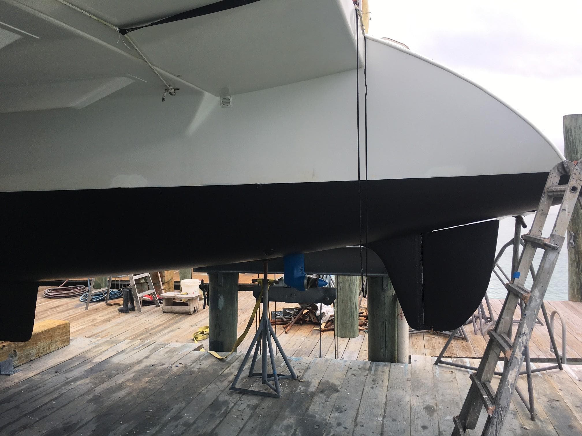 Voyage Mayotte 47 catamaran hull on dry dock, 1995 model, undergoing maintenance.