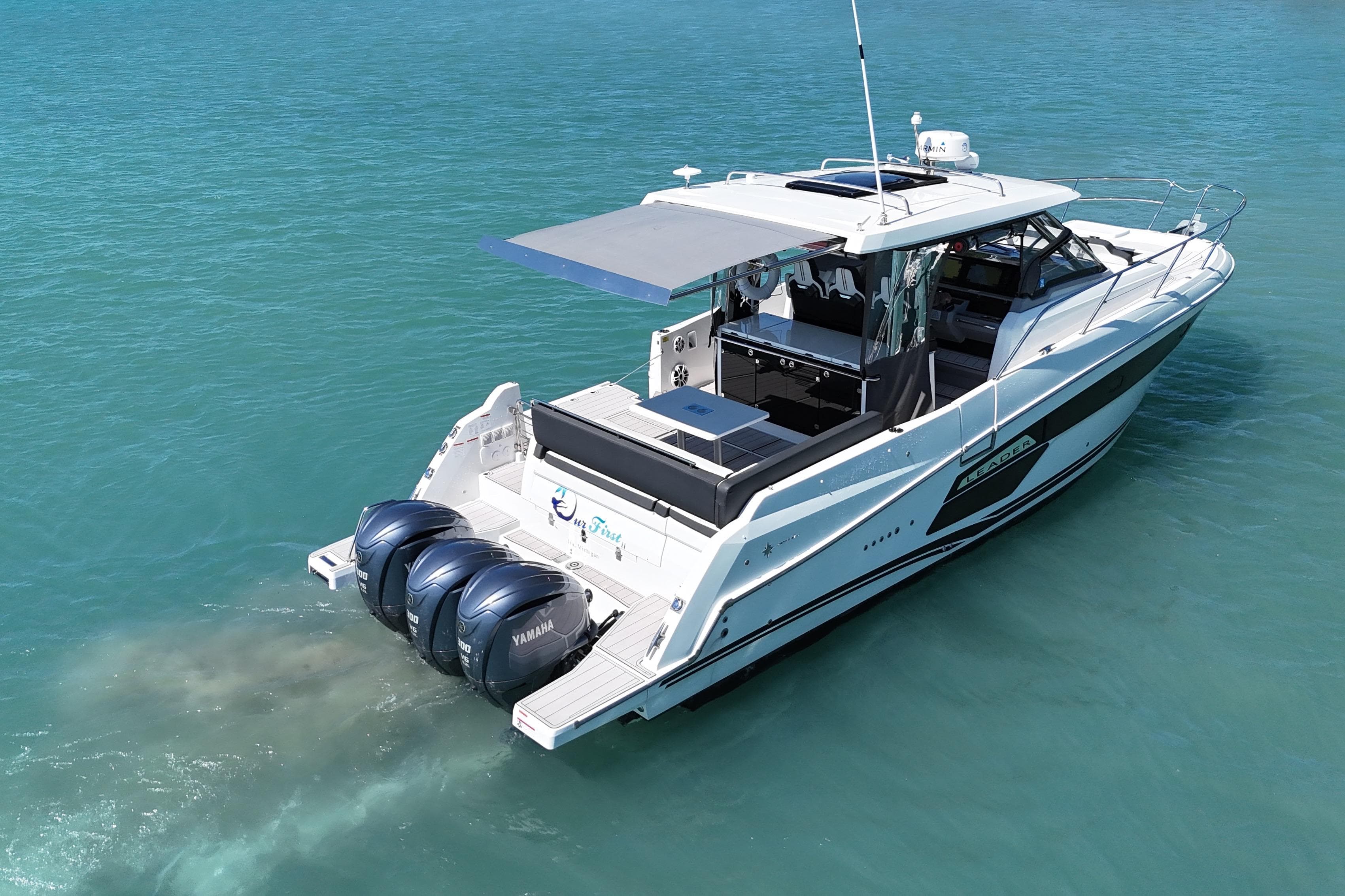 2023 Jeanneau Leader 12.5 WA boat with triple Yamaha engines on clear blue water.