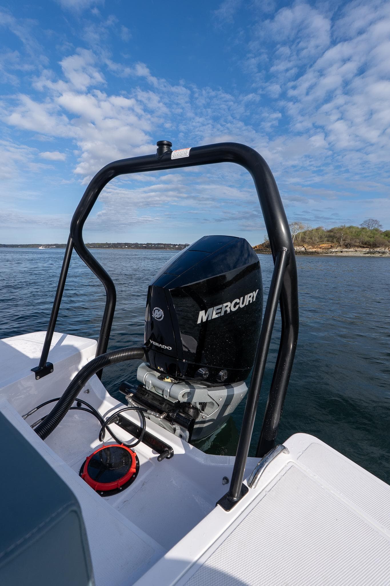 2025 Axopar Cross Top boat with Mercury engine on a calm lake.