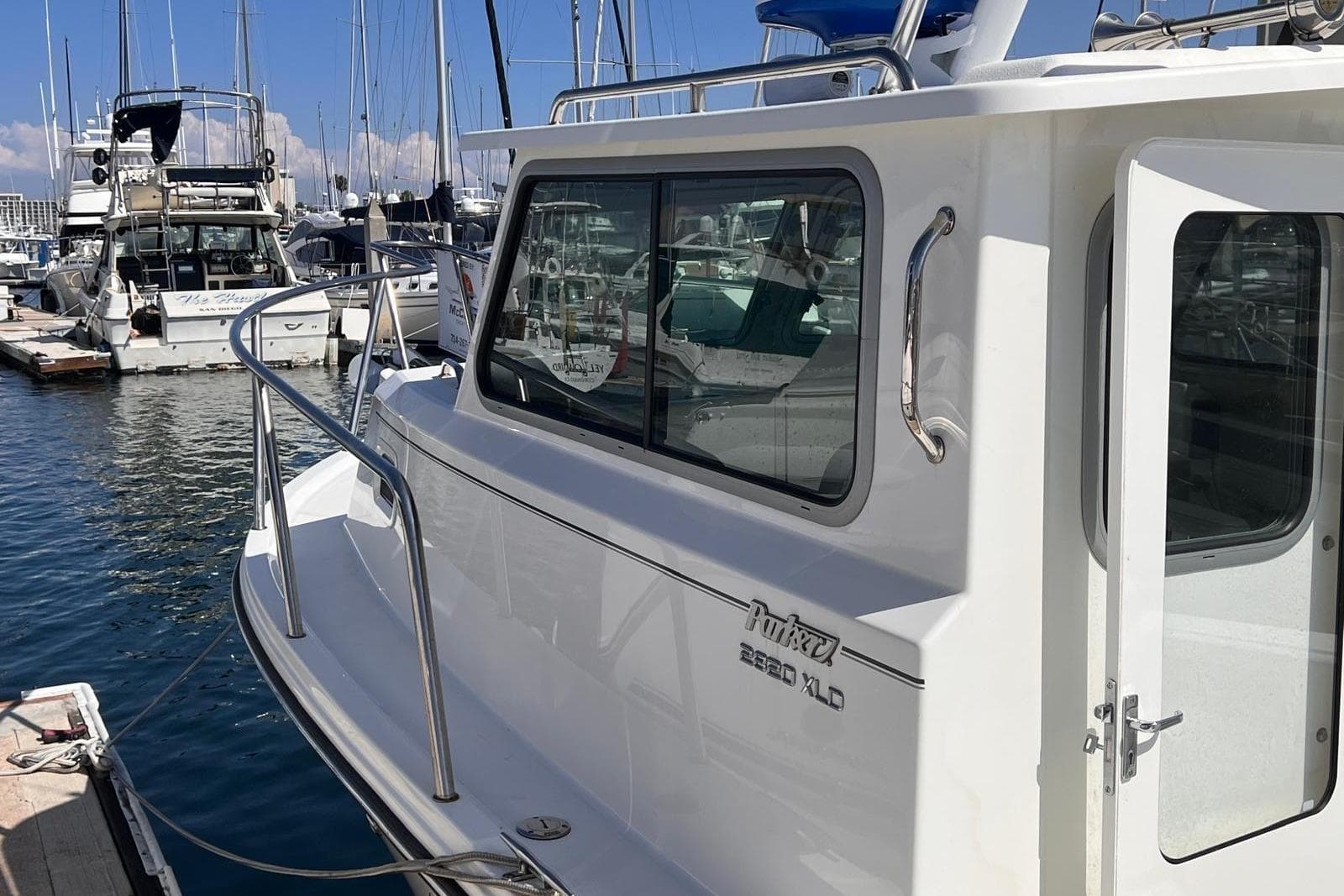 2023 Parker 2820 XLD Sport Cabin boat docked at marina, side view.