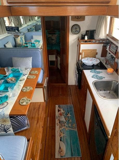 Interior of 1985 Roughwater 36 boat with cozy dining and kitchen area.