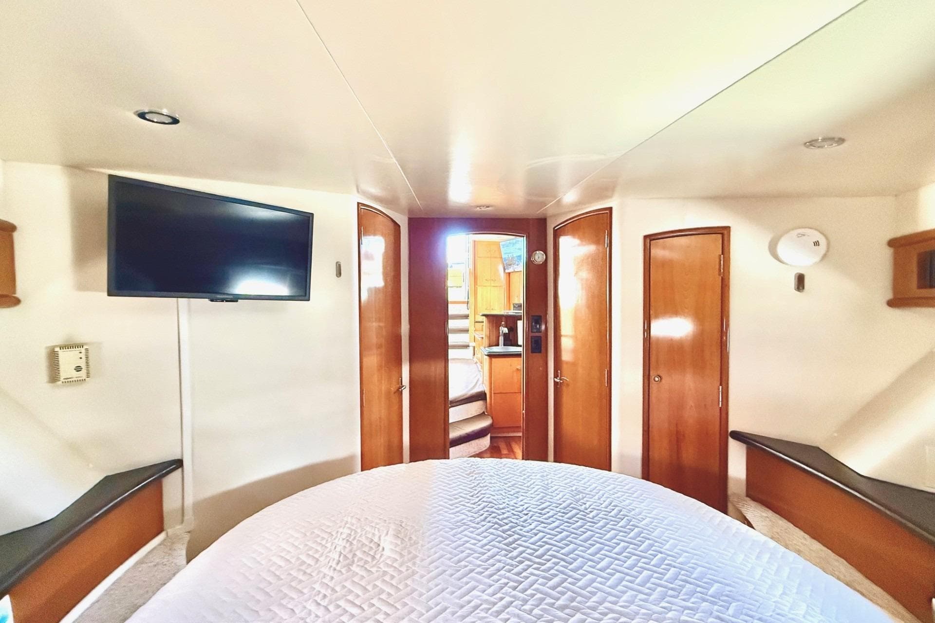 Luxurious interior of 2001 Carver 444 Cockpit Motor Yacht with TV and wooden accents.