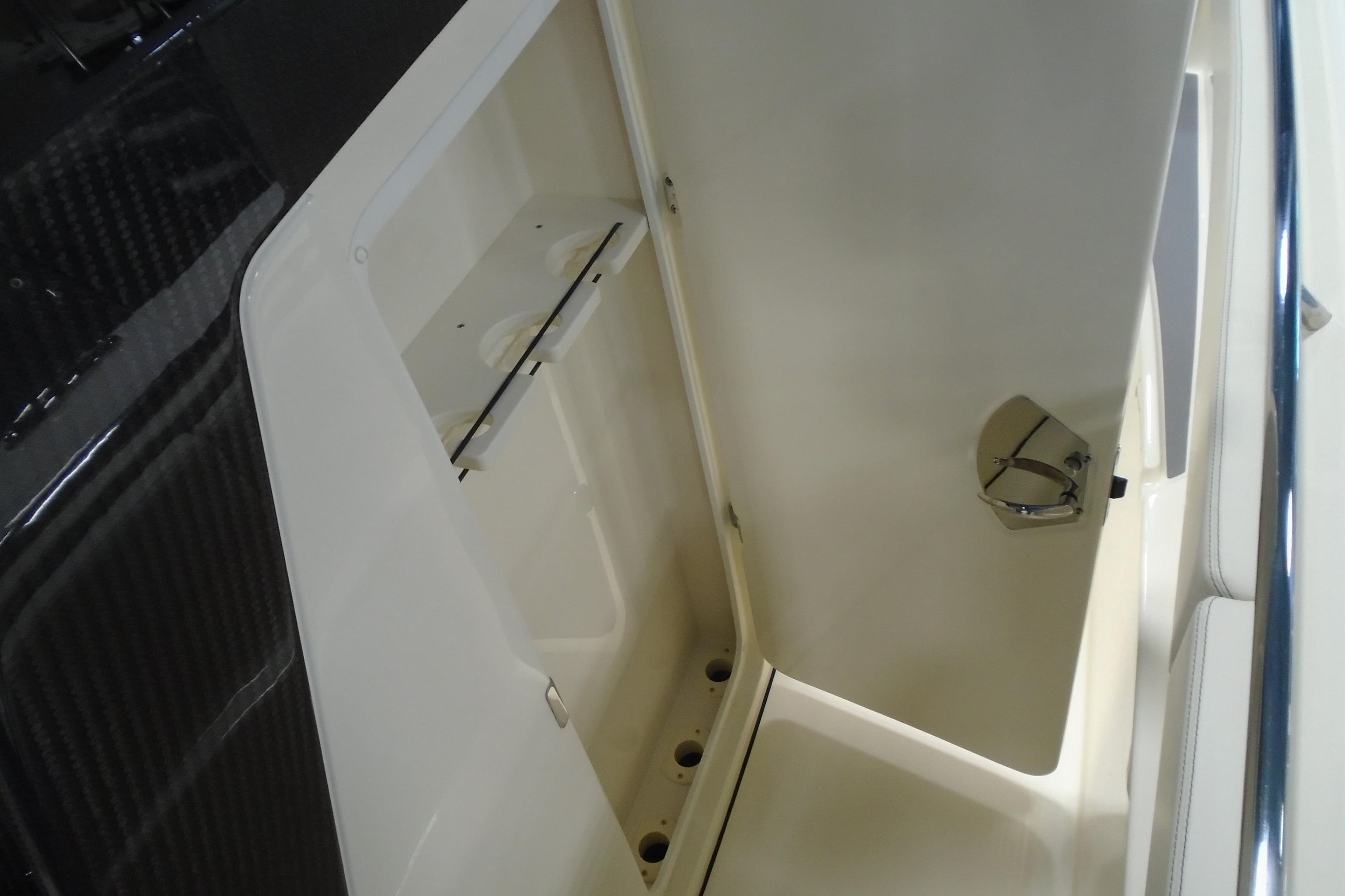 Open storage compartment on 2026 Scout 288 LXF boat, showcasing interior space.