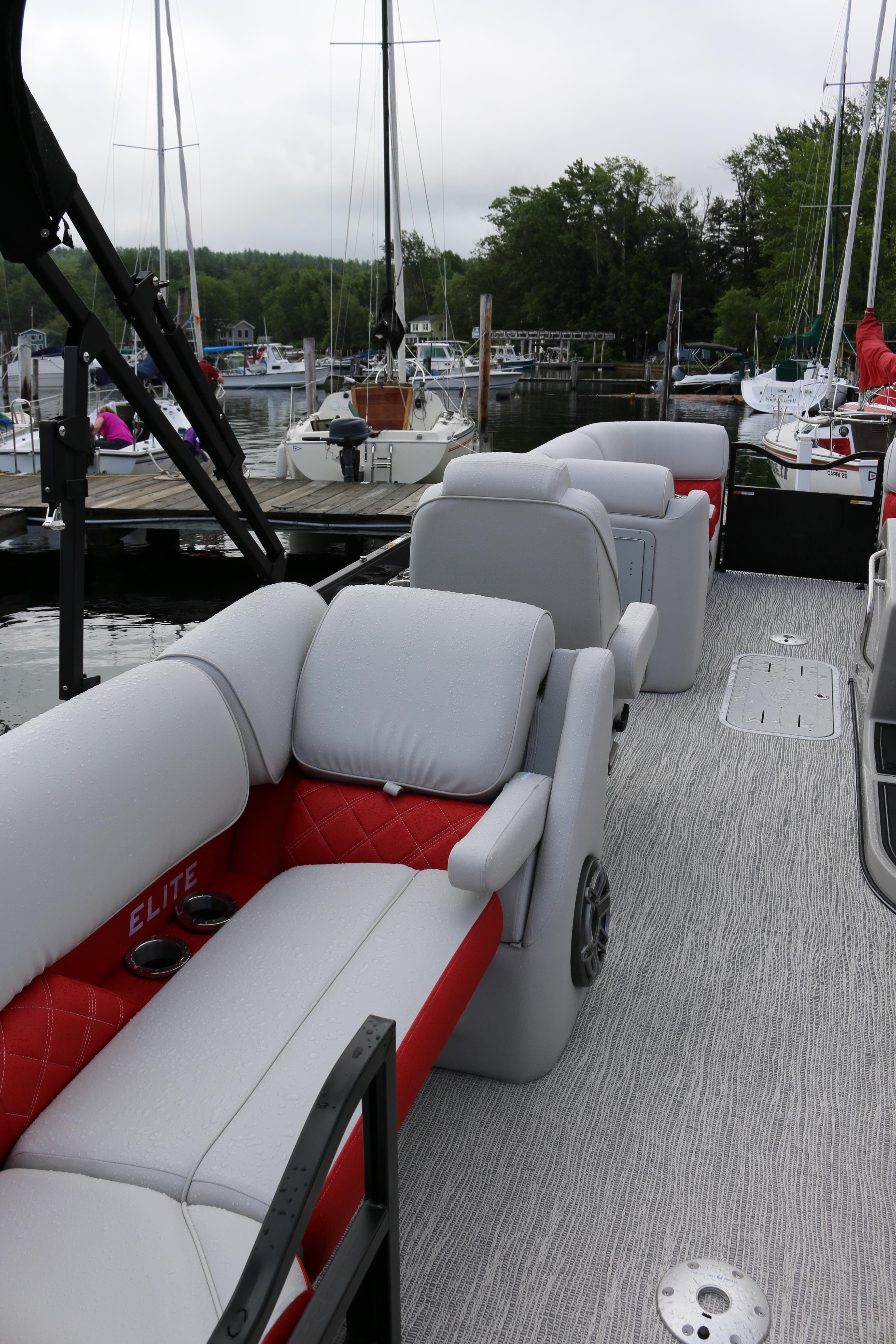 2025 SunCatcher Elite 324 RC pontoon boat with luxurious seating at a marina.