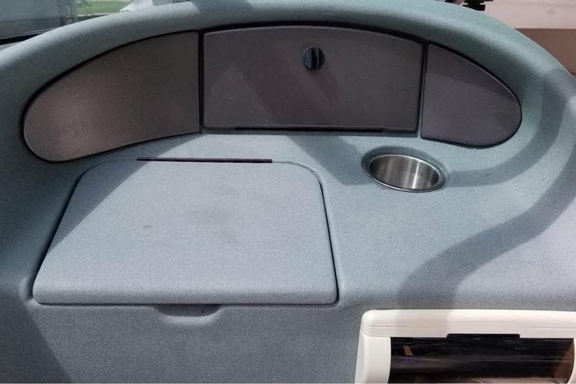 1999 Donzi Z22 boat dashboard with storage compartments and cup holder.