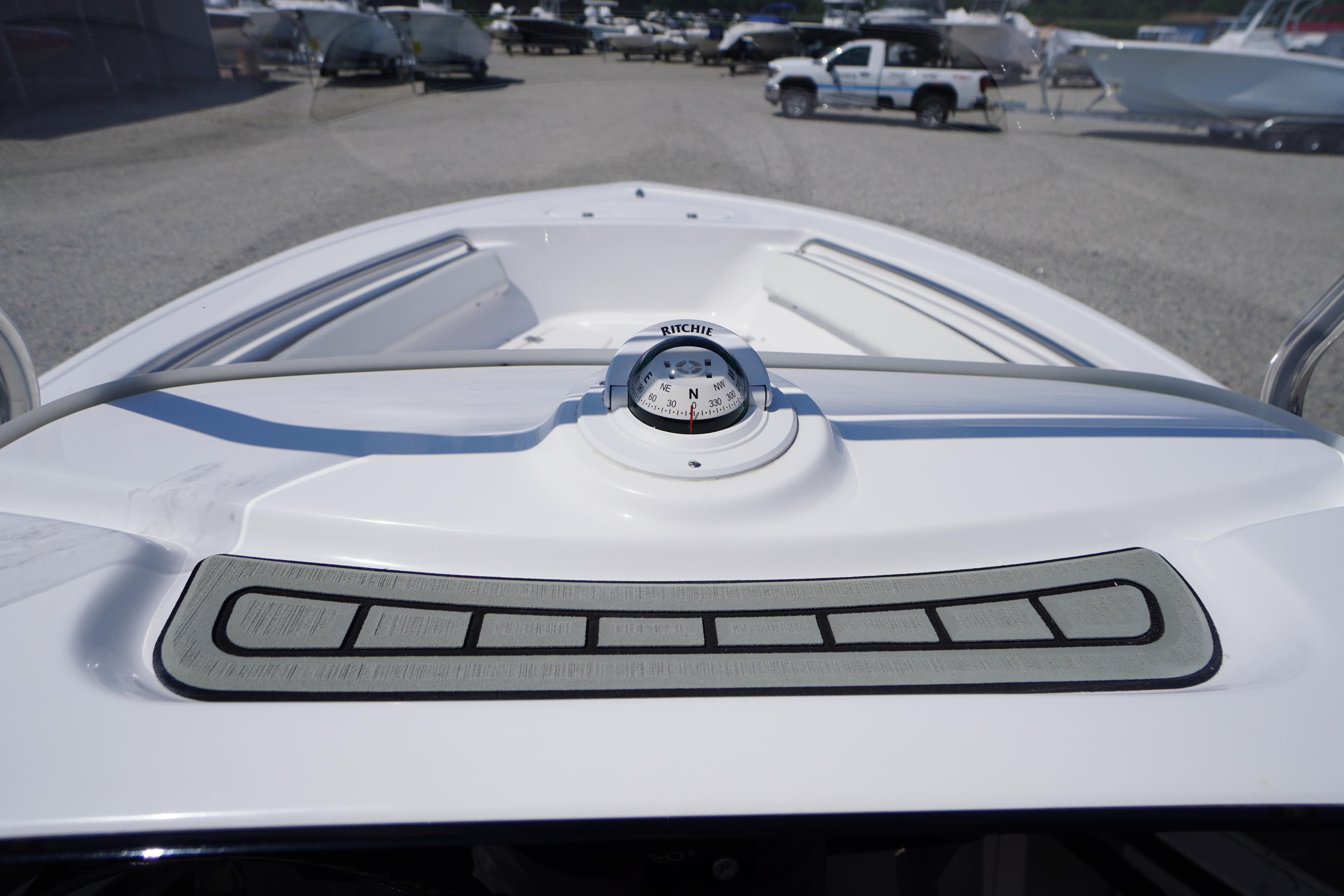 2025 Tidewater 198 CC Adventure boat dashboard with compass, parked in a marina.