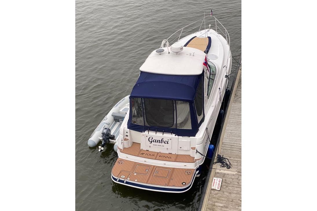 2007 Four Winns 278 Vista boat docked with inflatable dinghy attached.