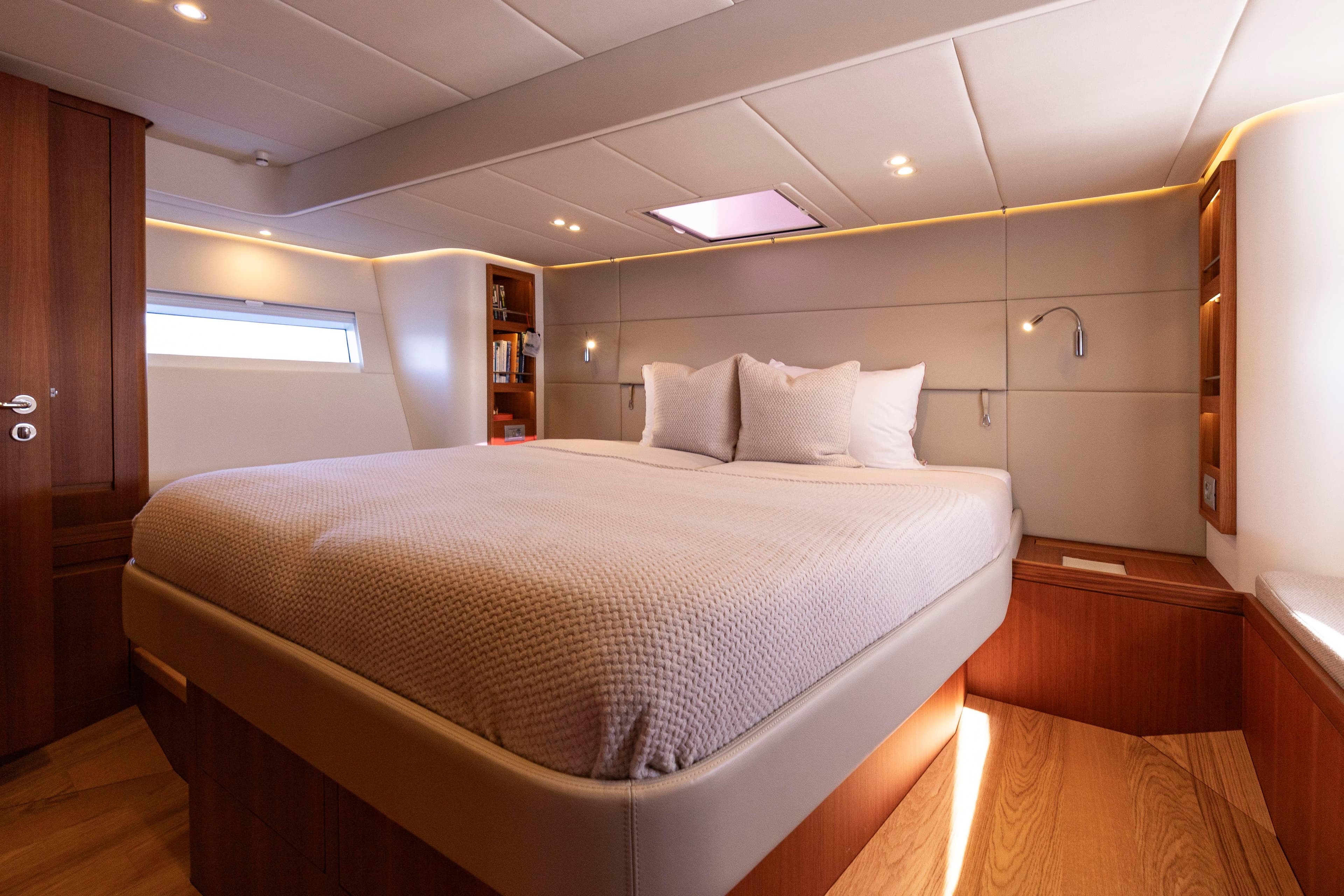 Luxurious cabin interior of 2021 Contest 55CS yacht with cozy bed and modern lighting.