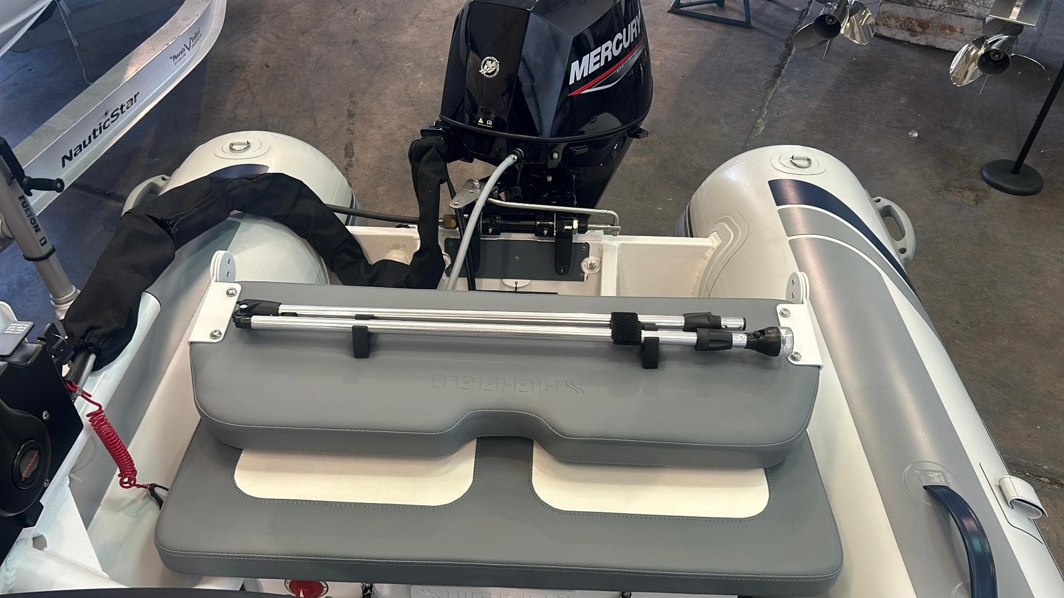 2025 Highfield CL380 inflatable boat with Mercury outboard motor, featuring a gray seat and steering mechanism.