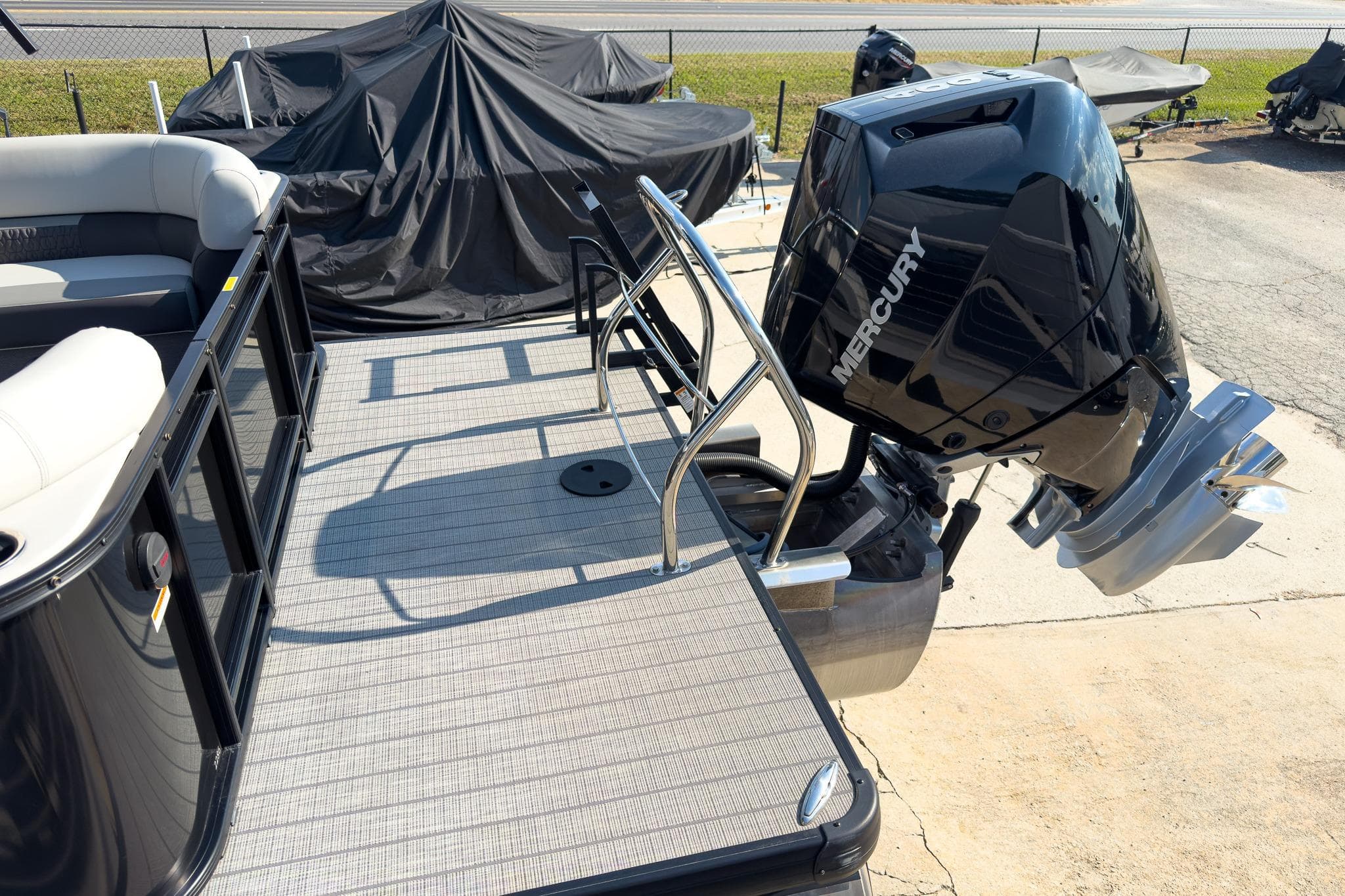 2024 Godfrey Sweetwater 22' pontoon boat with Mercury 400 V10 engine, docked outdoors.