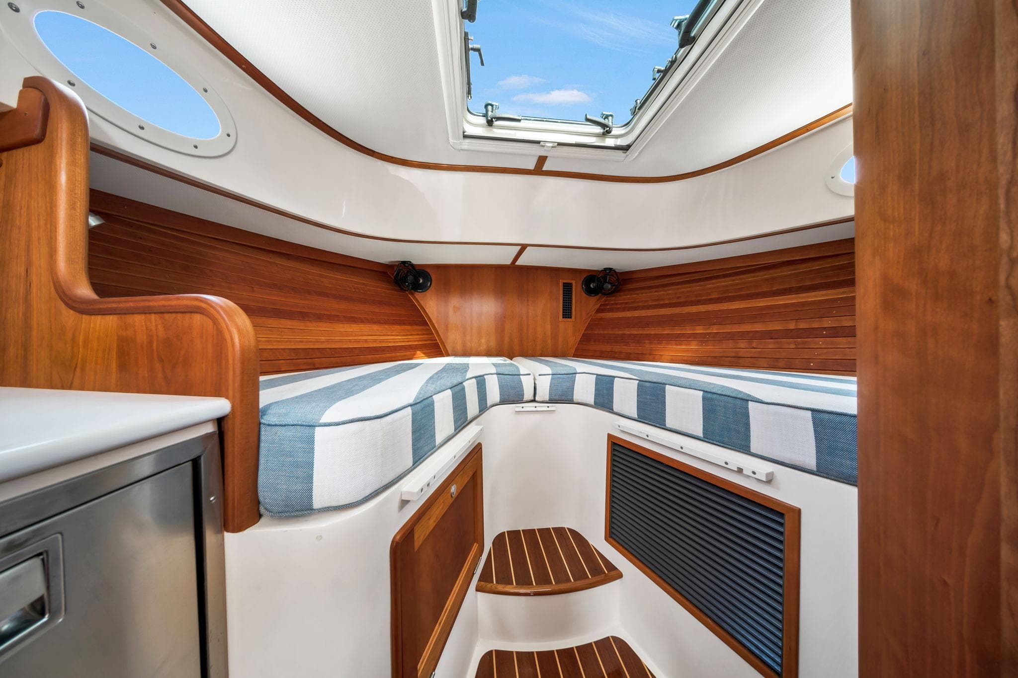 2019 Hinckley Picnic Boat 34 interior with wood accents and striped cushions.