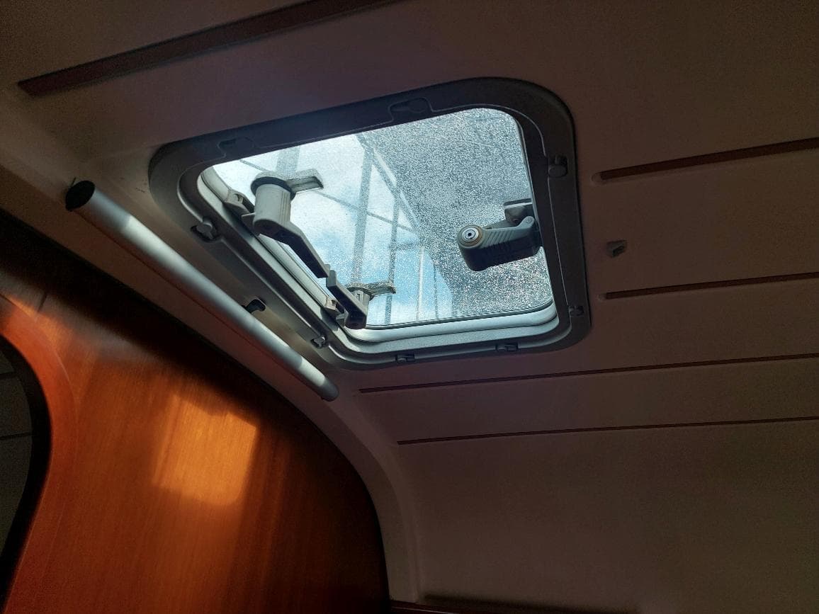 Interior view of a 1995 Beneteau Oceanis 351 hatch with wooden paneling.