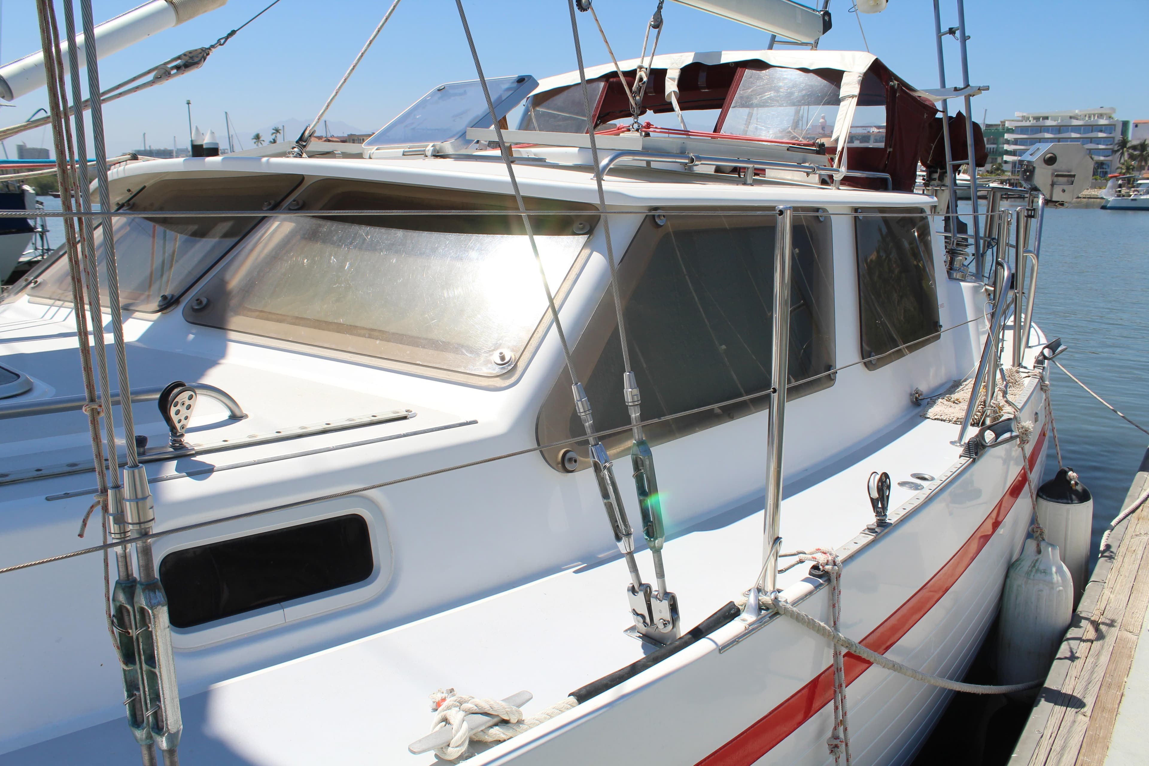 Sailboat docked at marina, Creascent Custom 1992 model, featuring sleek design and red stripe.