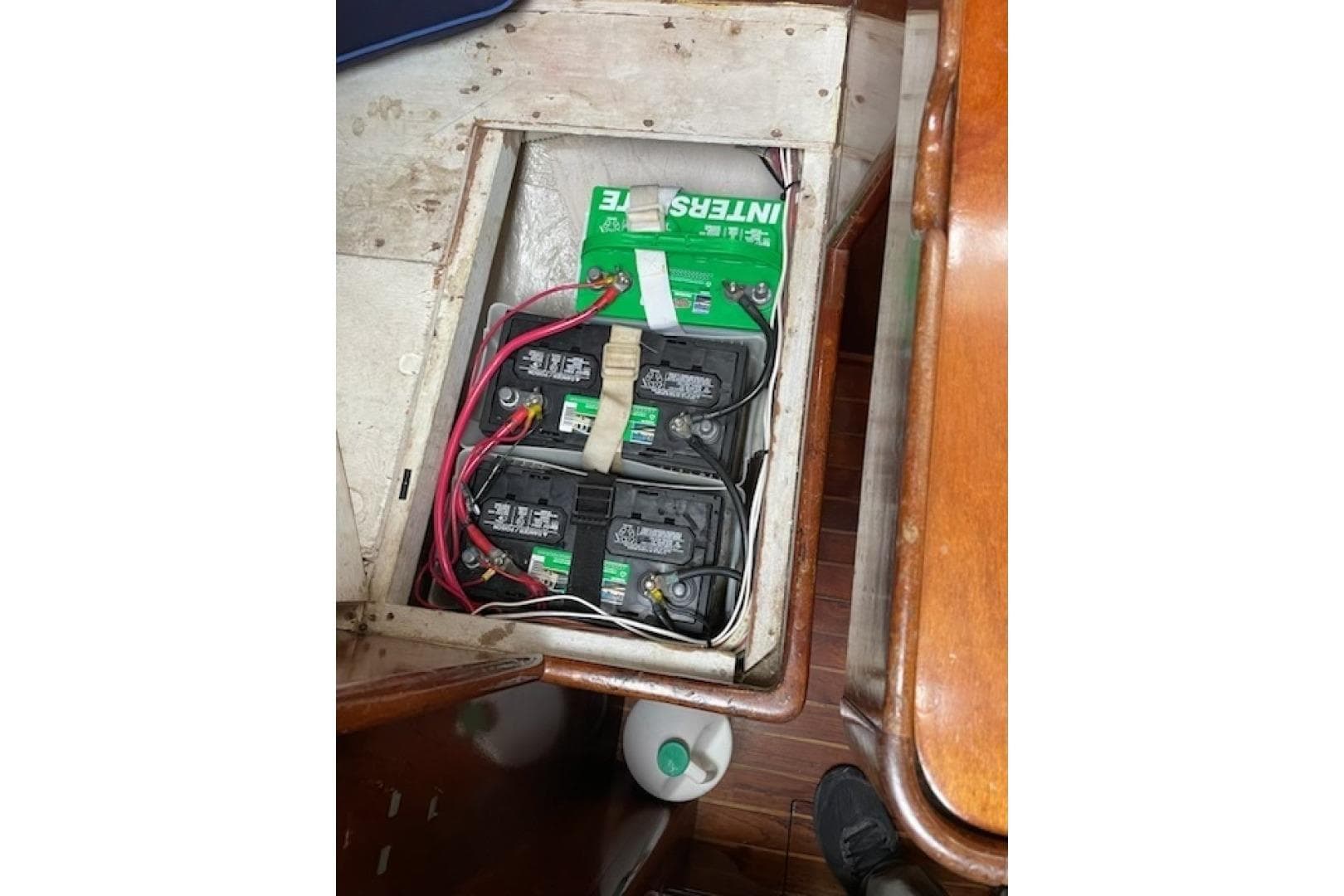 Battery compartment of a 1980 Bristol 35.5 sailboat with multiple batteries and wiring.