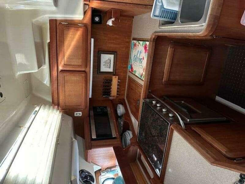 Interior of 1991 Hunter Passage 42 sailboat with wooden cabinetry and kitchen amenities.