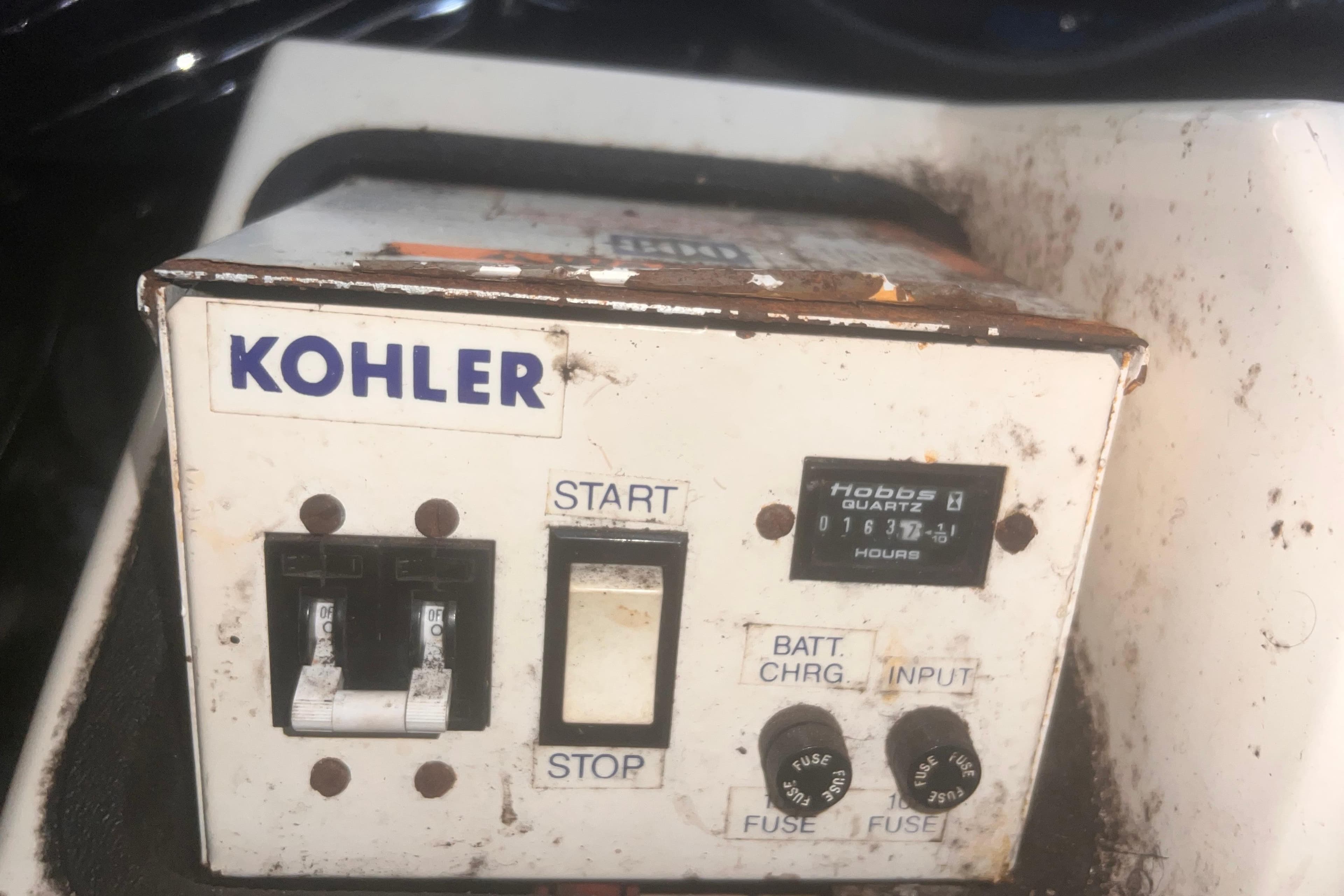 Kohler control panel on a 1994 Carver 350 boat, showing switches and hour meter.
