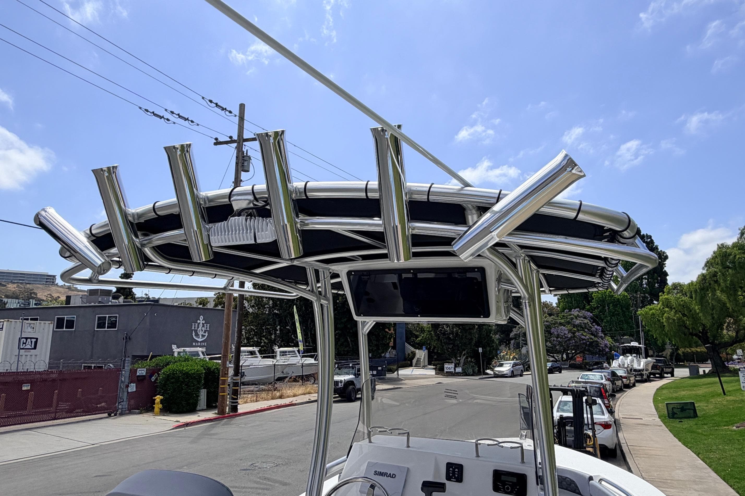 2026 Defiance Catalina 210 boat with stainless steel rod holders and canopy, parked on a street.