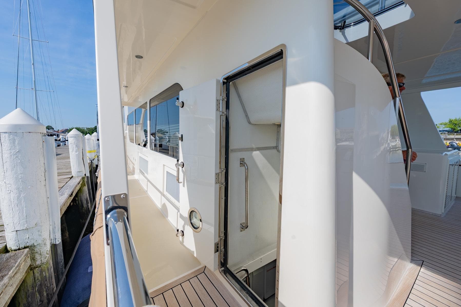 2016 Grand Banks 72 Aleutian RP yacht side deck with open hatch and marina view.
