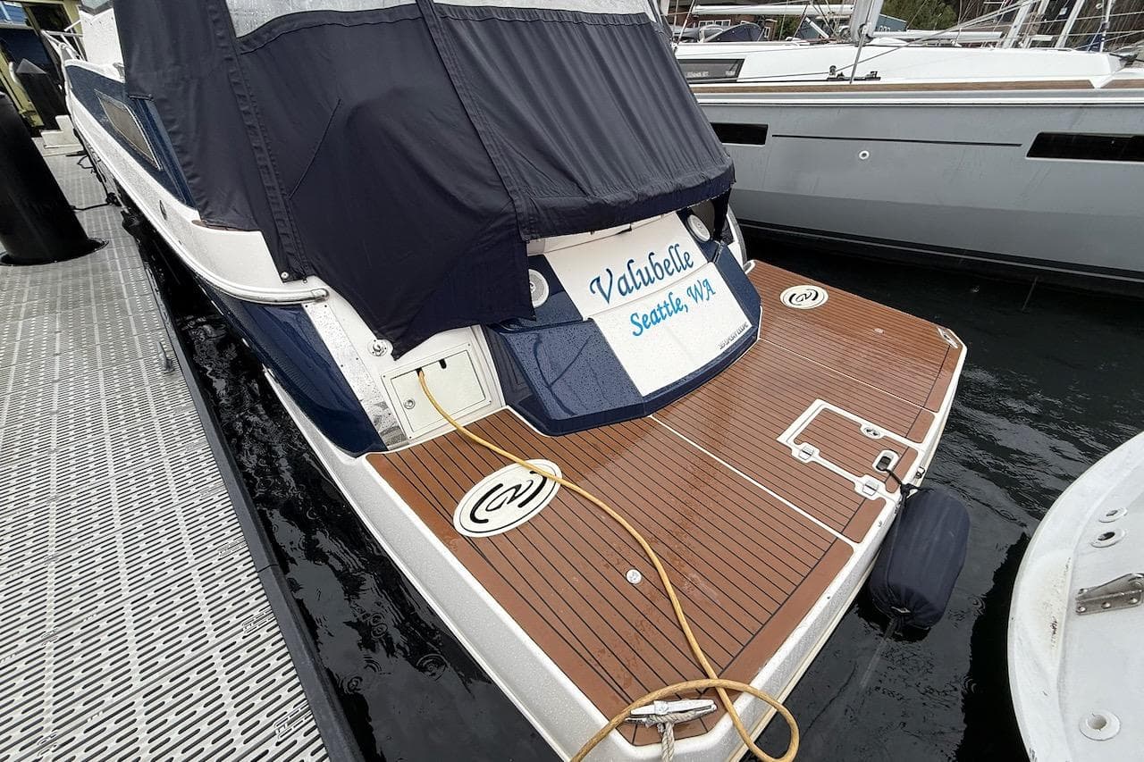 2012 Regal 35 Sport Coupe docked, featuring teak swim platform and covered cockpit.