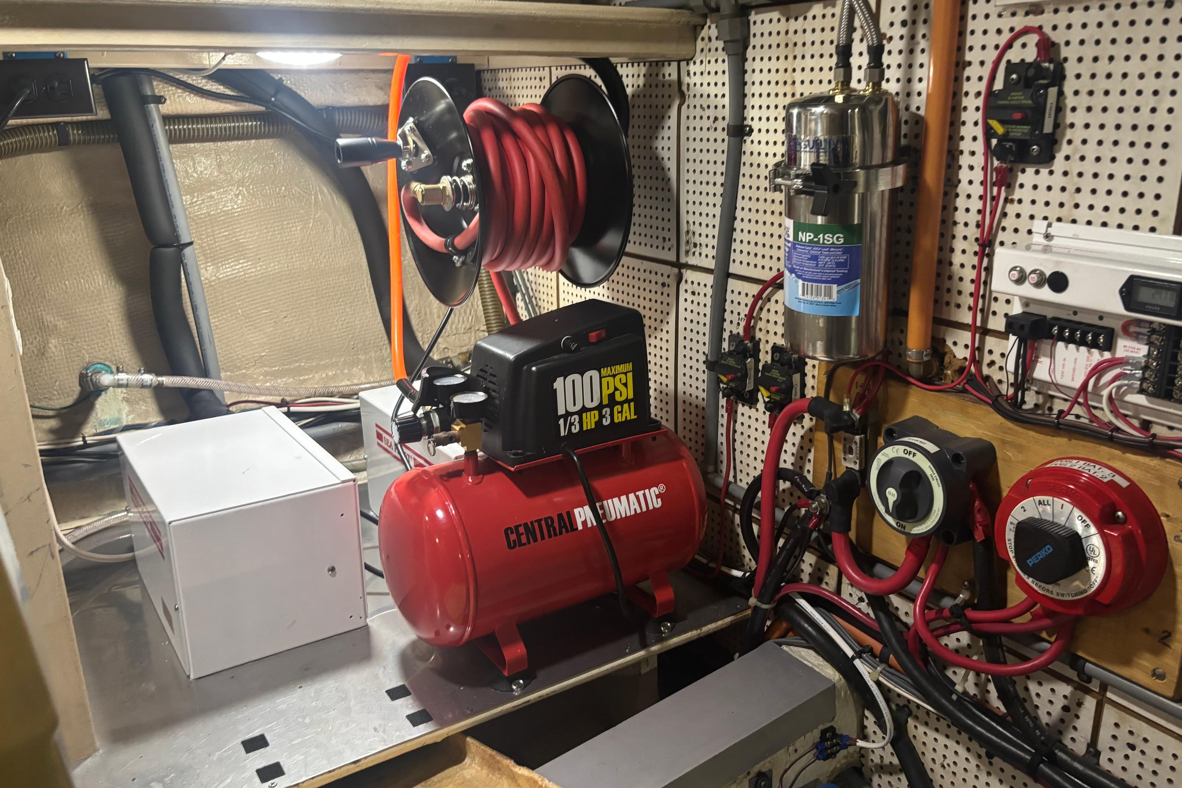 Engine room of 1989 Grand Banks 46 Classic with air compressor and electrical components.