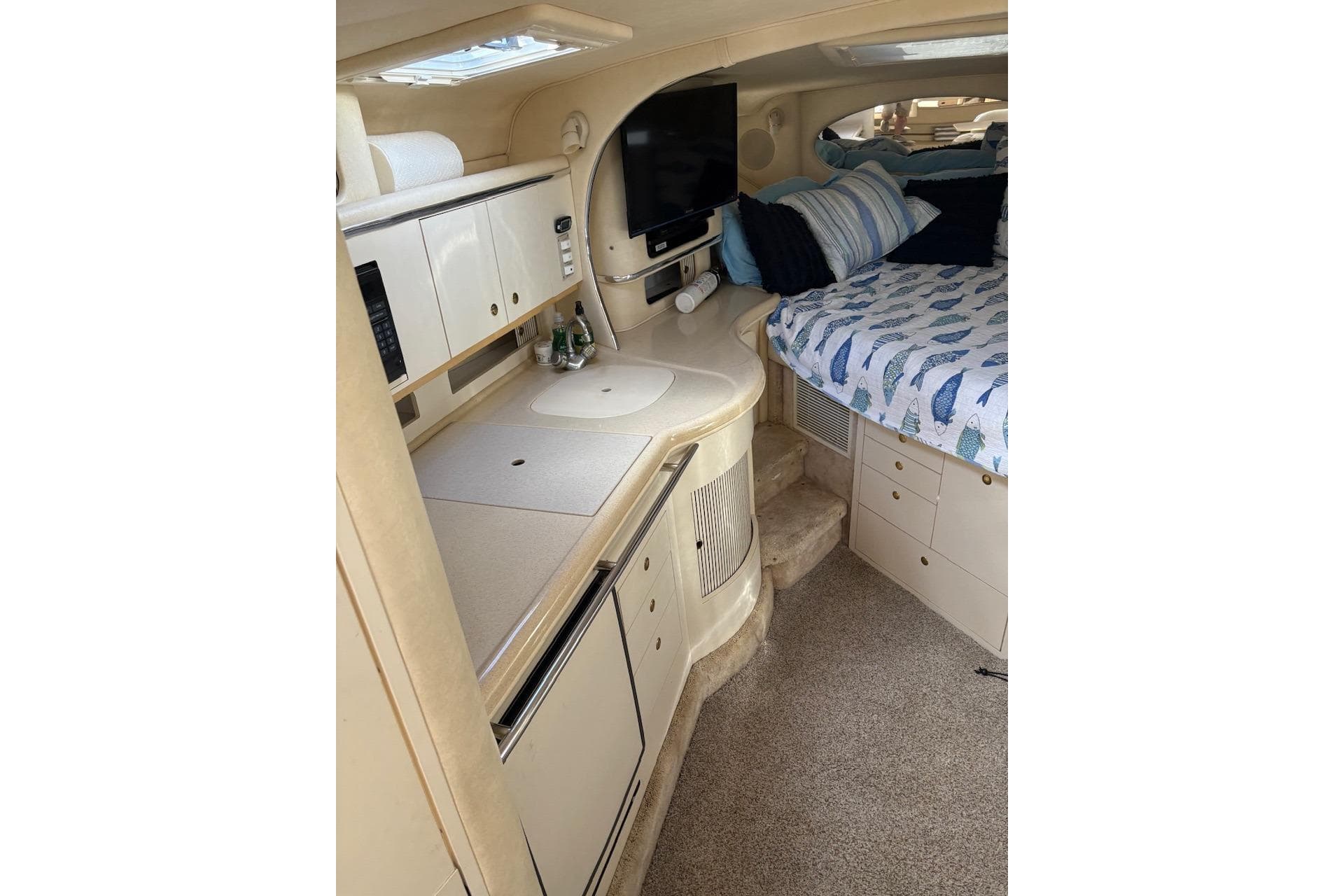 Interior of 2000 Sea Ray 310 Sundancer with kitchenette and cozy sleeping area.
