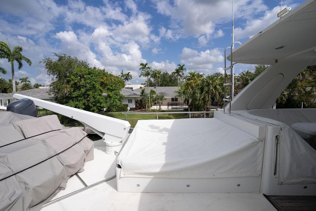 2004 Cheoy Lee 84 Bravo Flybridge yacht deck with scenic view of palm trees and houses.