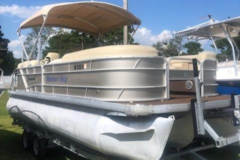 2018 Godfrey Sweetwater 2286C pontoon boat on trailer with canopy, parked outdoors.