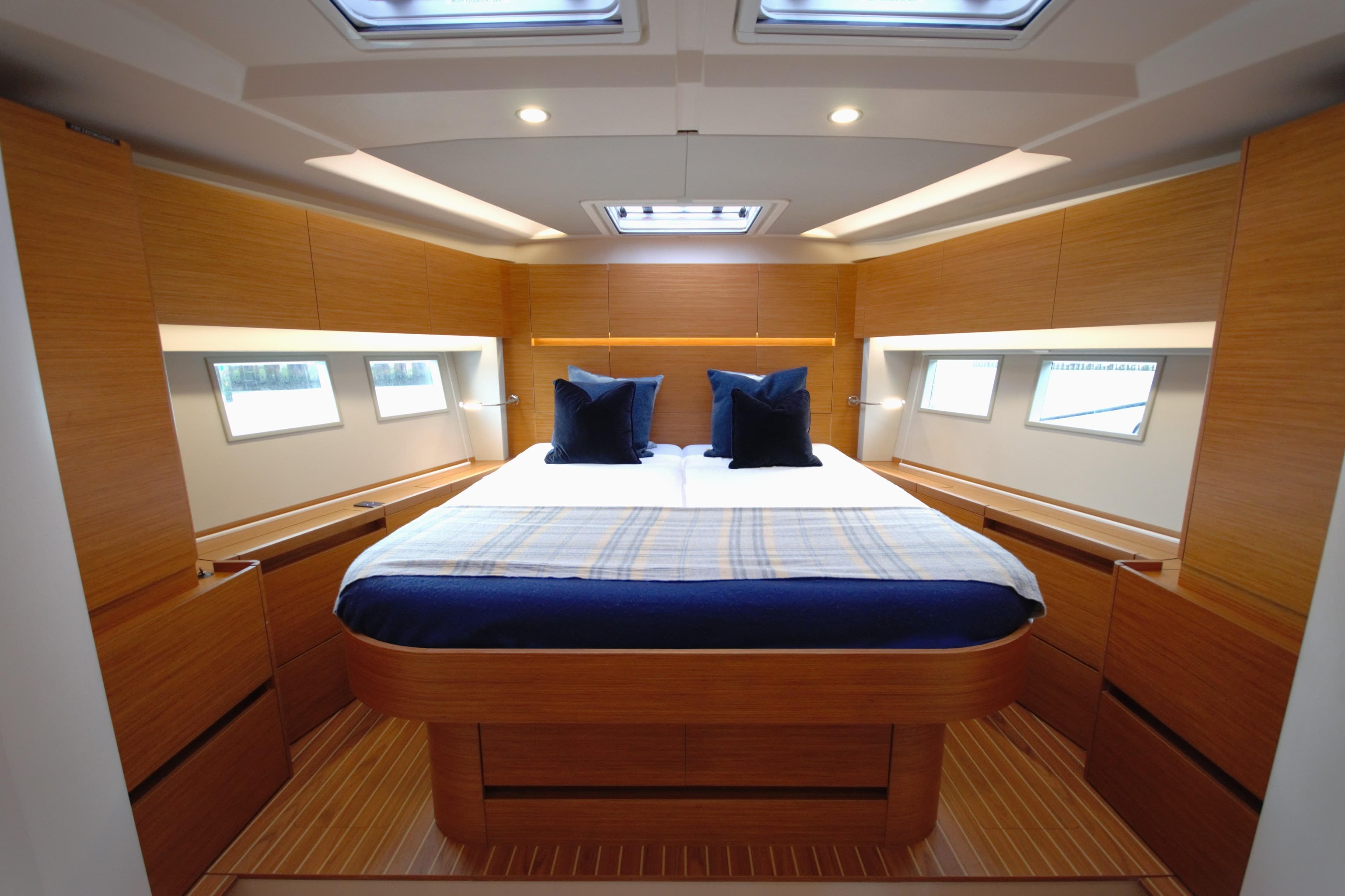 Luxurious cabin interior of 2021 Hanse 588 yacht with modern wood finish and skylights.