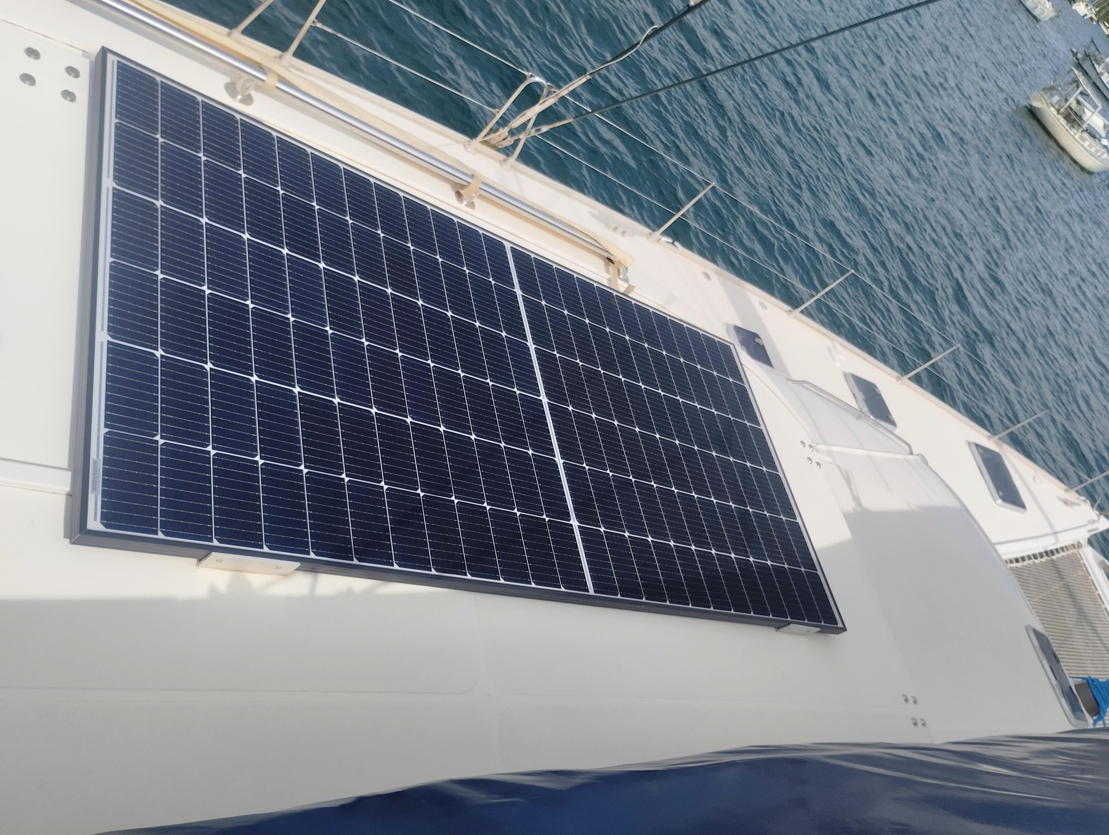 Solar panels on 2004 Lagoon 570 yacht deck, docked by the sea.