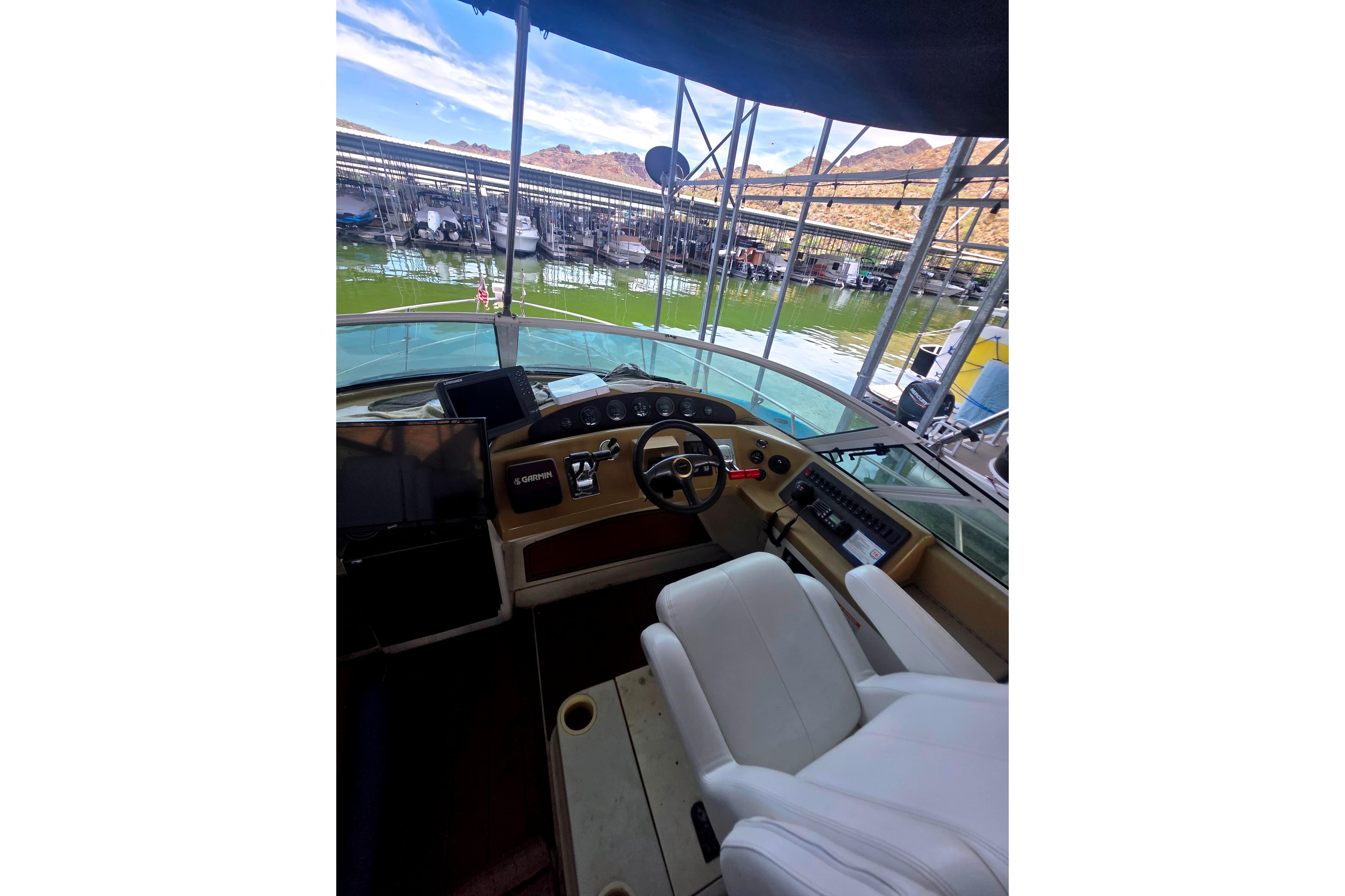 Interior view of 2001 Carver 350 Mariner yacht helm with marina backdrop.