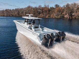 2026 Front Runner 37 Cat boat cruising on a calm river with forested banks.