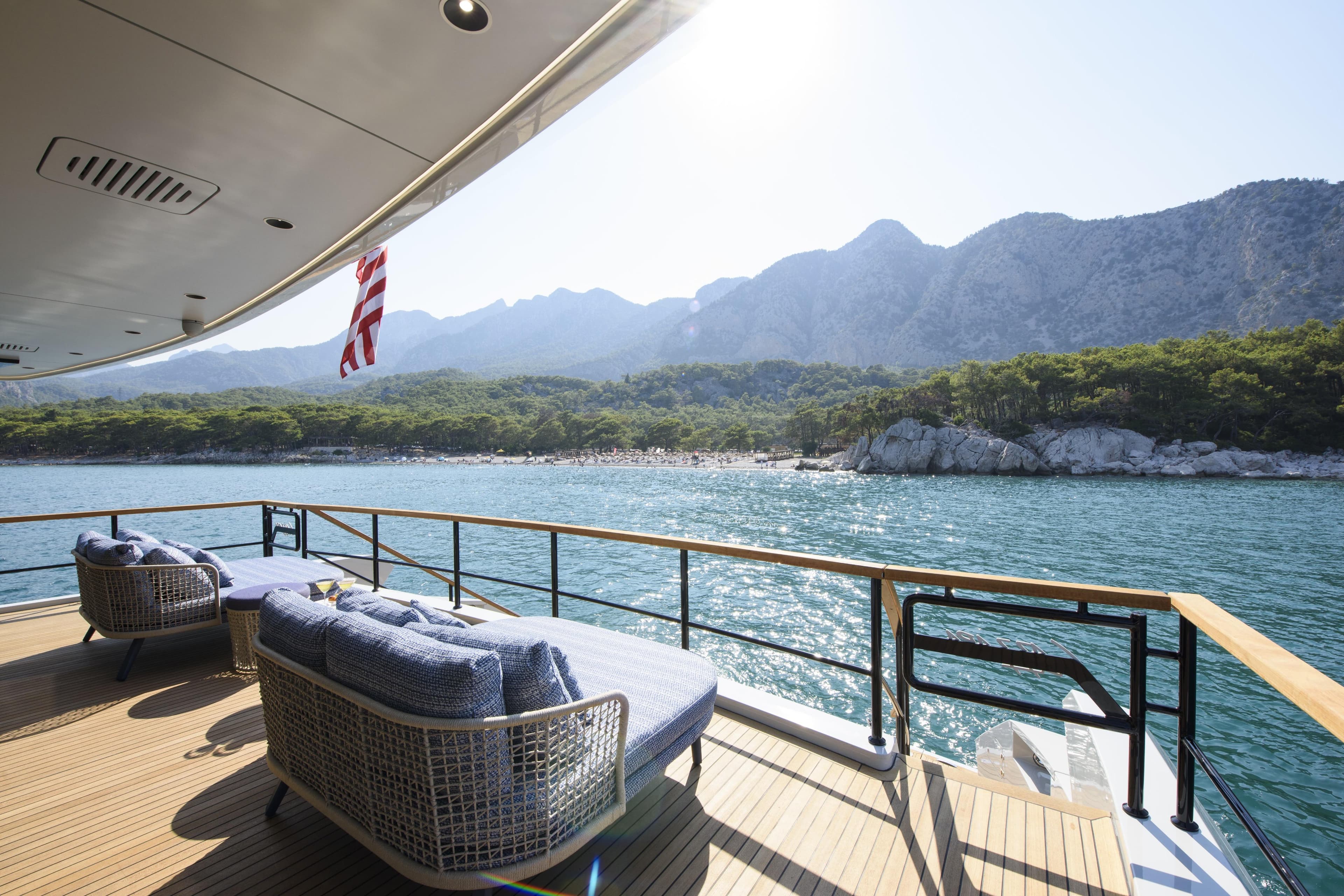 Luxurious Lazzara LPC 300 yacht deck with scenic mountain and ocean view, 2027 model.