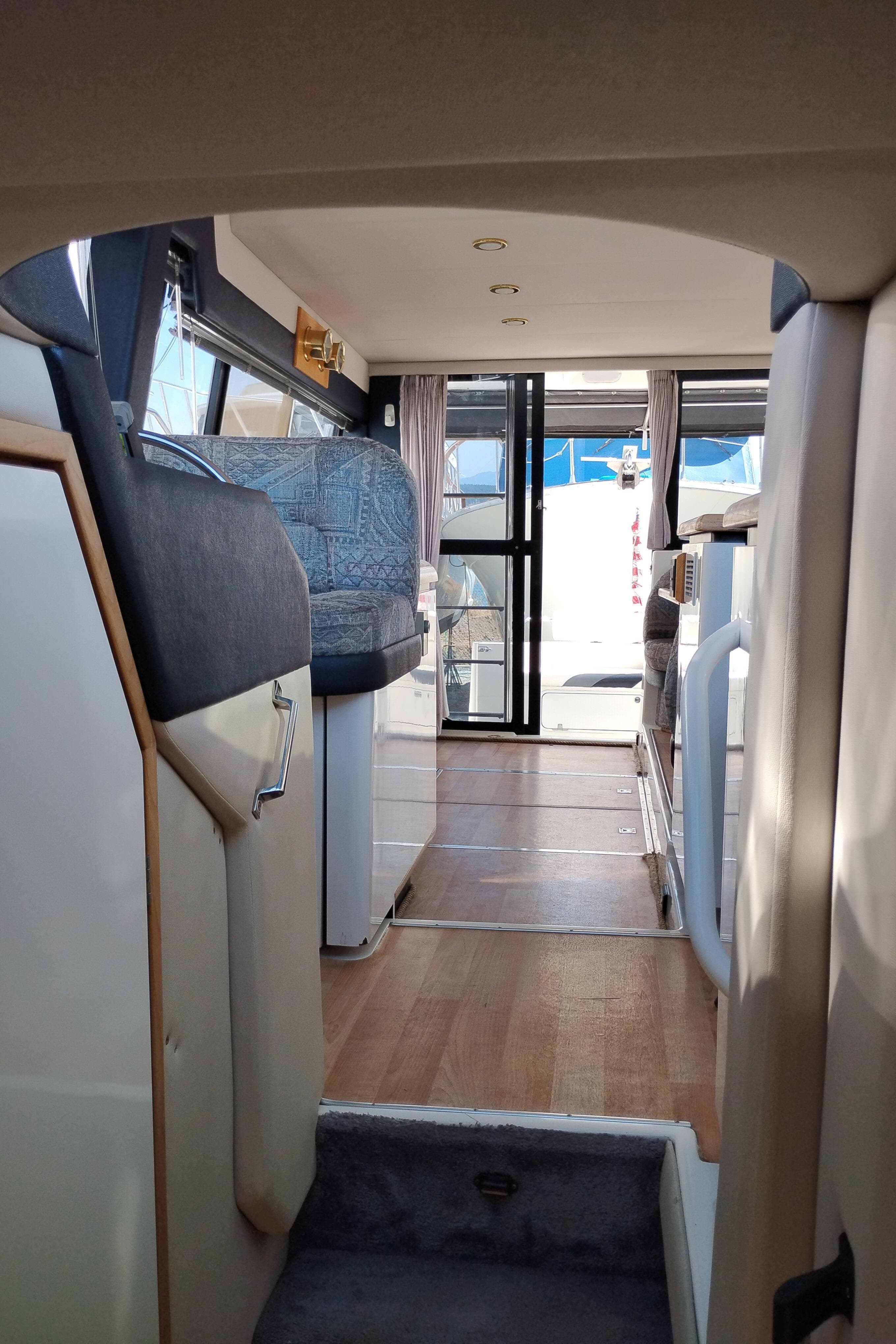 Interior view of 1992 Bayliner 4388 Motoryacht, featuring seating and wooden flooring.