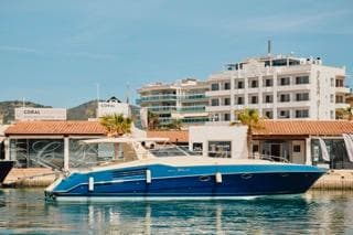 1994 Riva RIVA 51 TURBOROSSO yacht docked in a marina with buildings in the background.